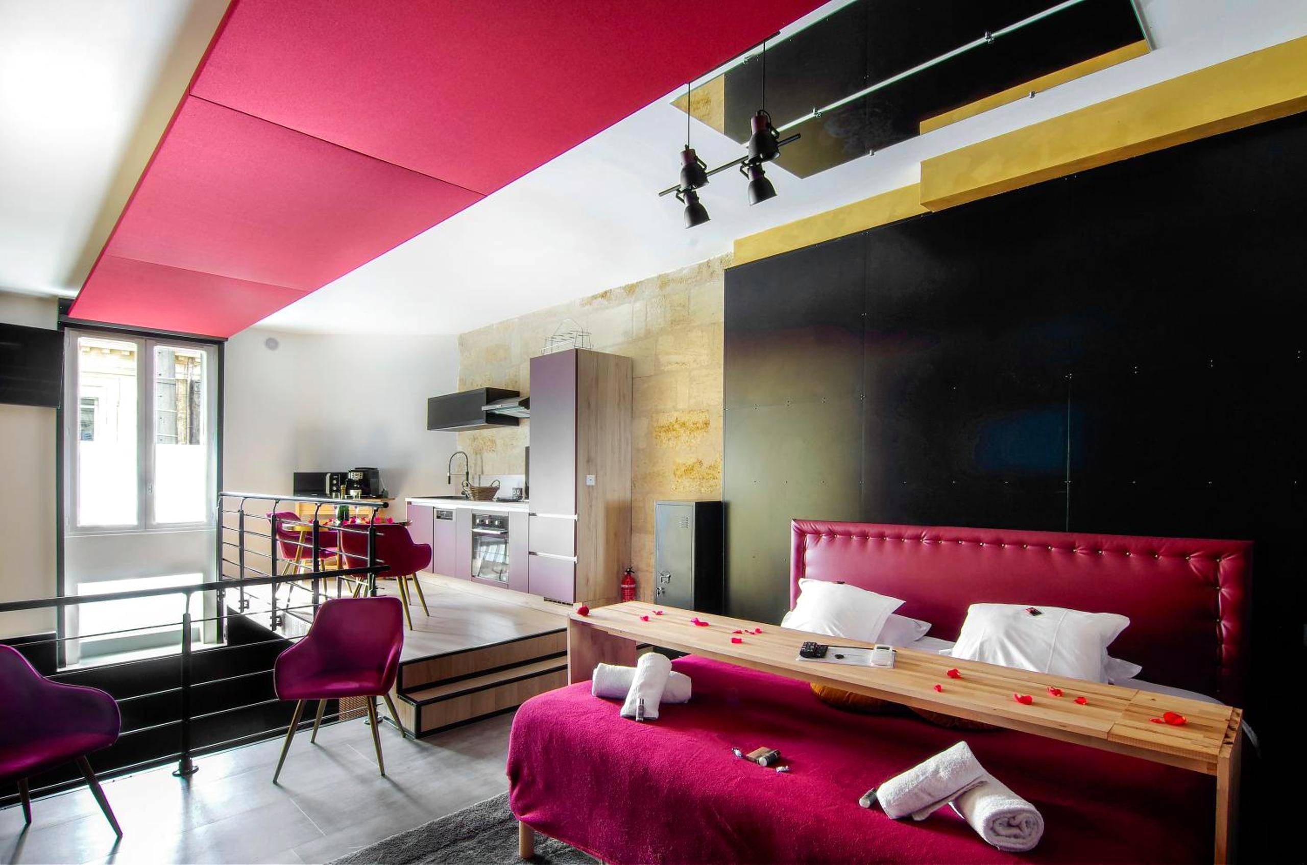 Suite avec lit rouge et table de lit en bois - Mieuxqualhotel jacuzzi privatif Love room