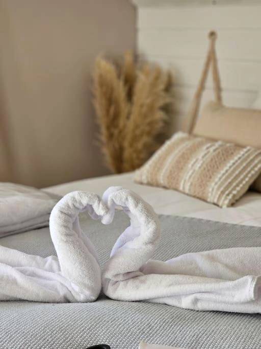 Cygnes en serviettes formant un cœur sur le lit - Un moment de détente