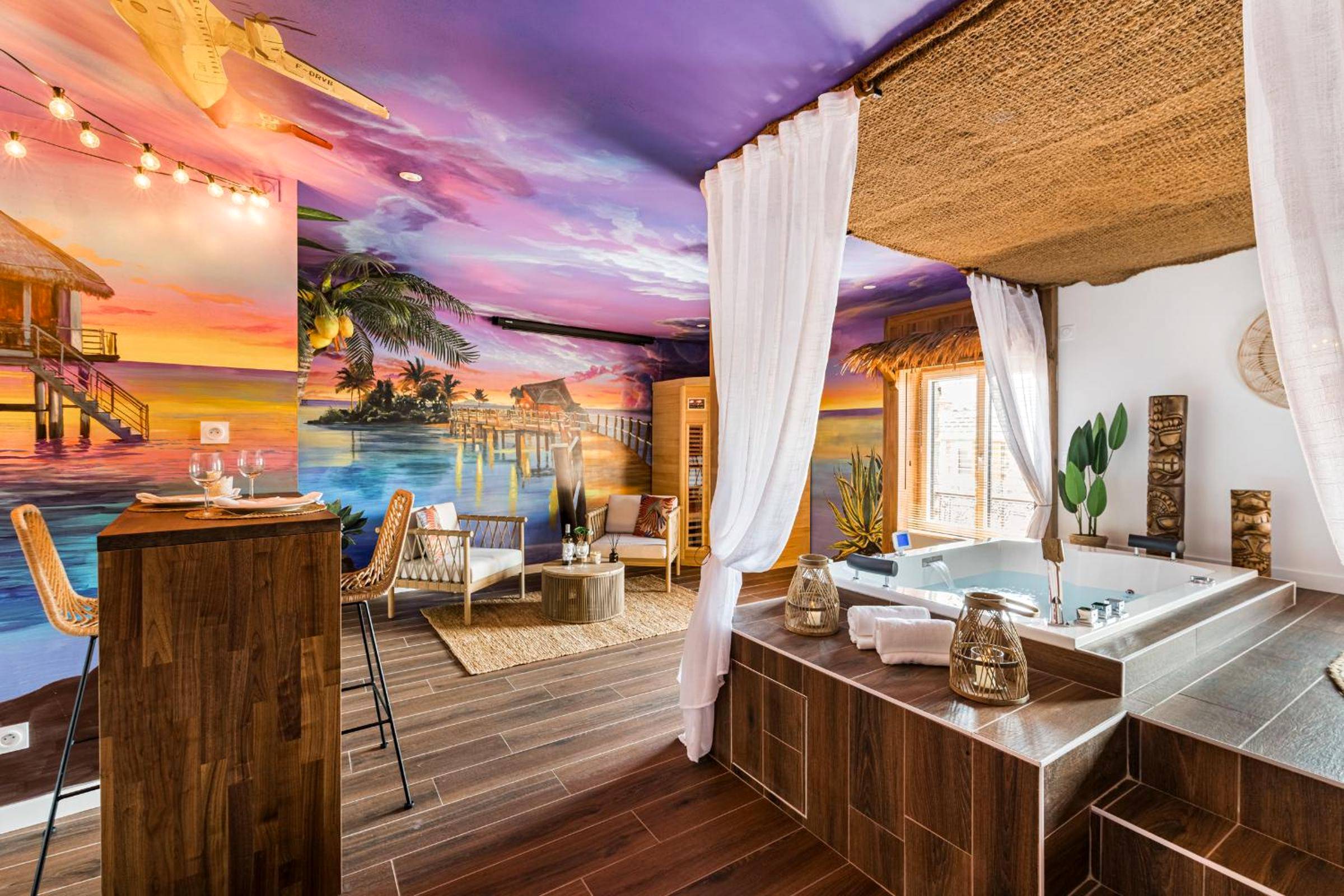 Jacuzzi et salon avec fresque tropicale - Love Room Annonay - Moments de douceur - Suite Laponie et Suite Tahiti