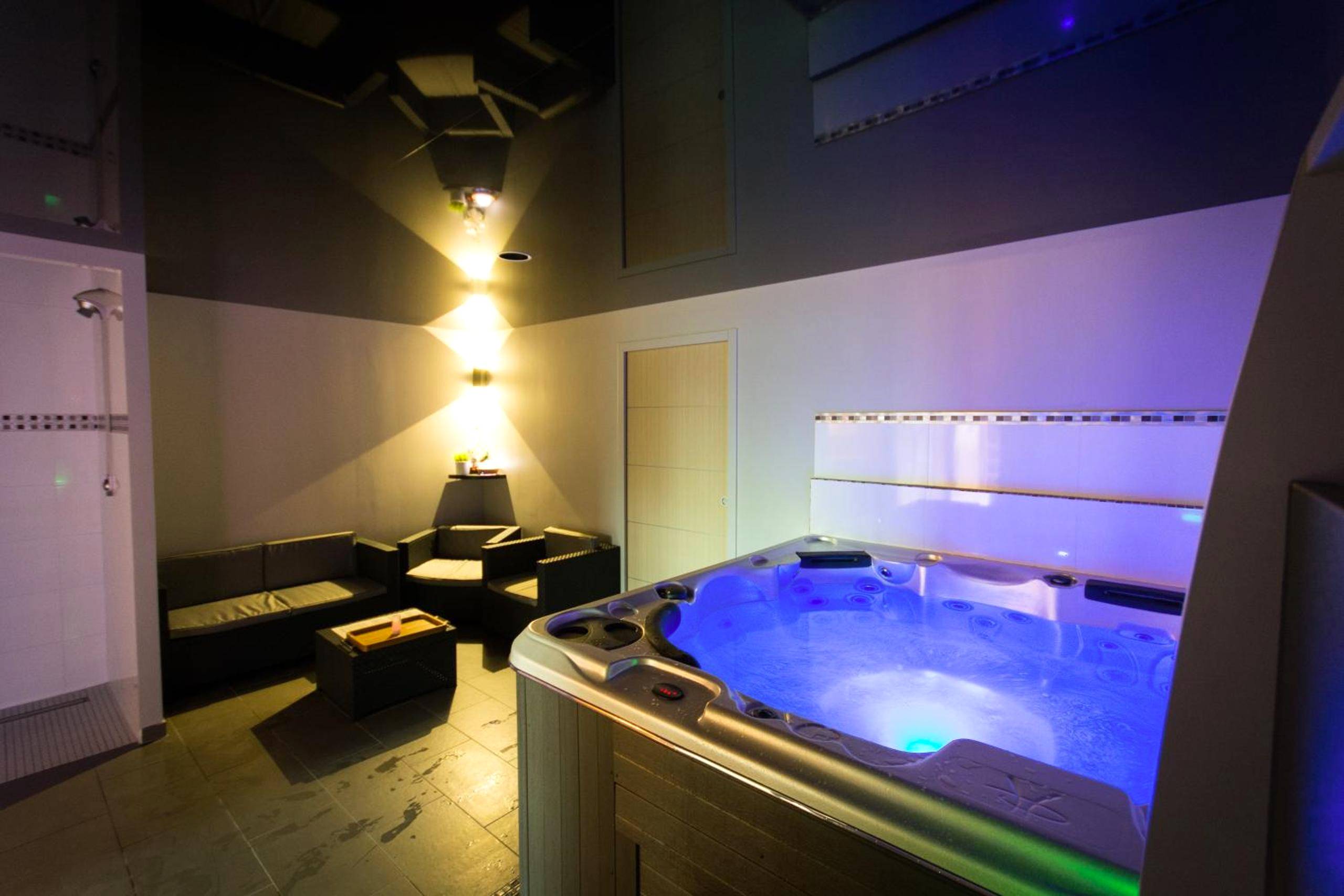 Jacuzzi privatif avec éclairage bleu et salon - Mon Cocoon Spa