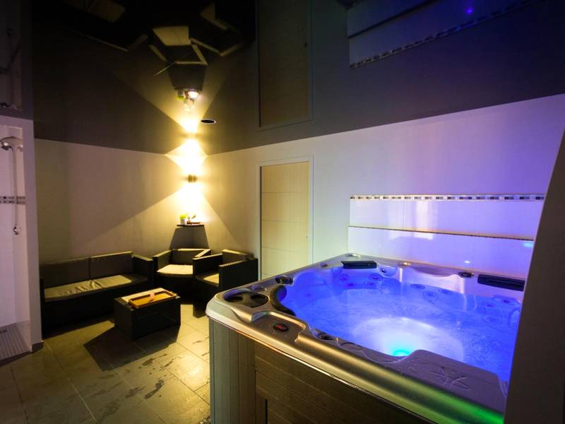 Jacuzzi privatif avec éclairage bleu et salon - Mon Cocoon Spa