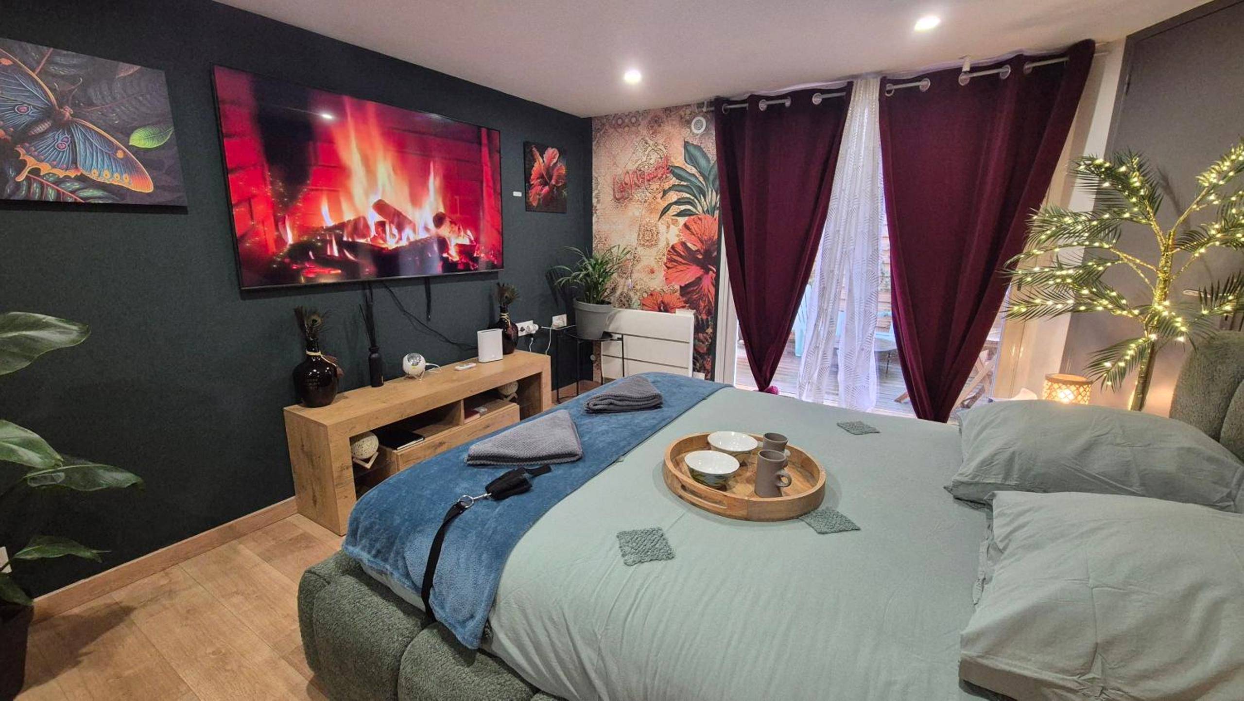Espace nuit avec décoration tropicale et TV - LoveRoom le moutik du bord de mer avec SPA et sauna parking gratuit