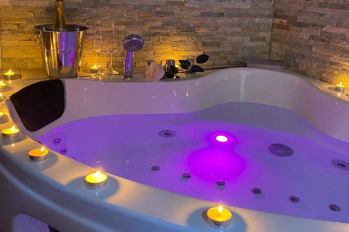 Jacuzzi avec bougies et seau à champagne - Love Room Caurel - Le Murmure de détente Guerlédan