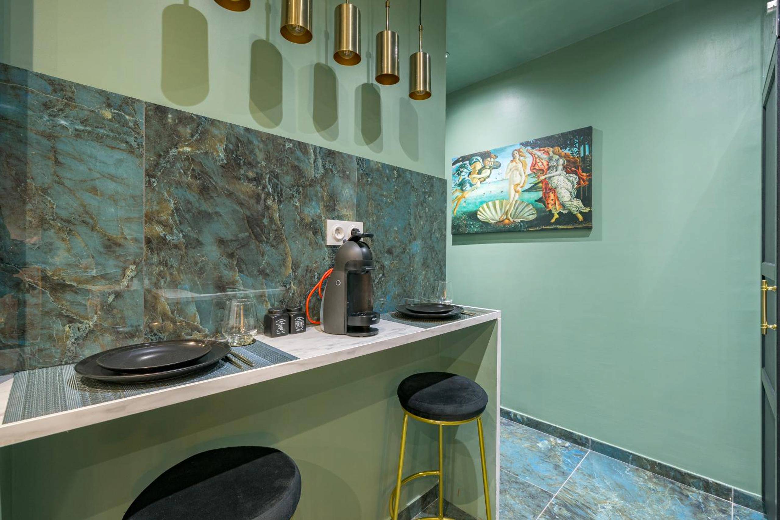 Espace repas avec tabourets et machine à café - Le Musée d’Aphrodite / JACUZZI