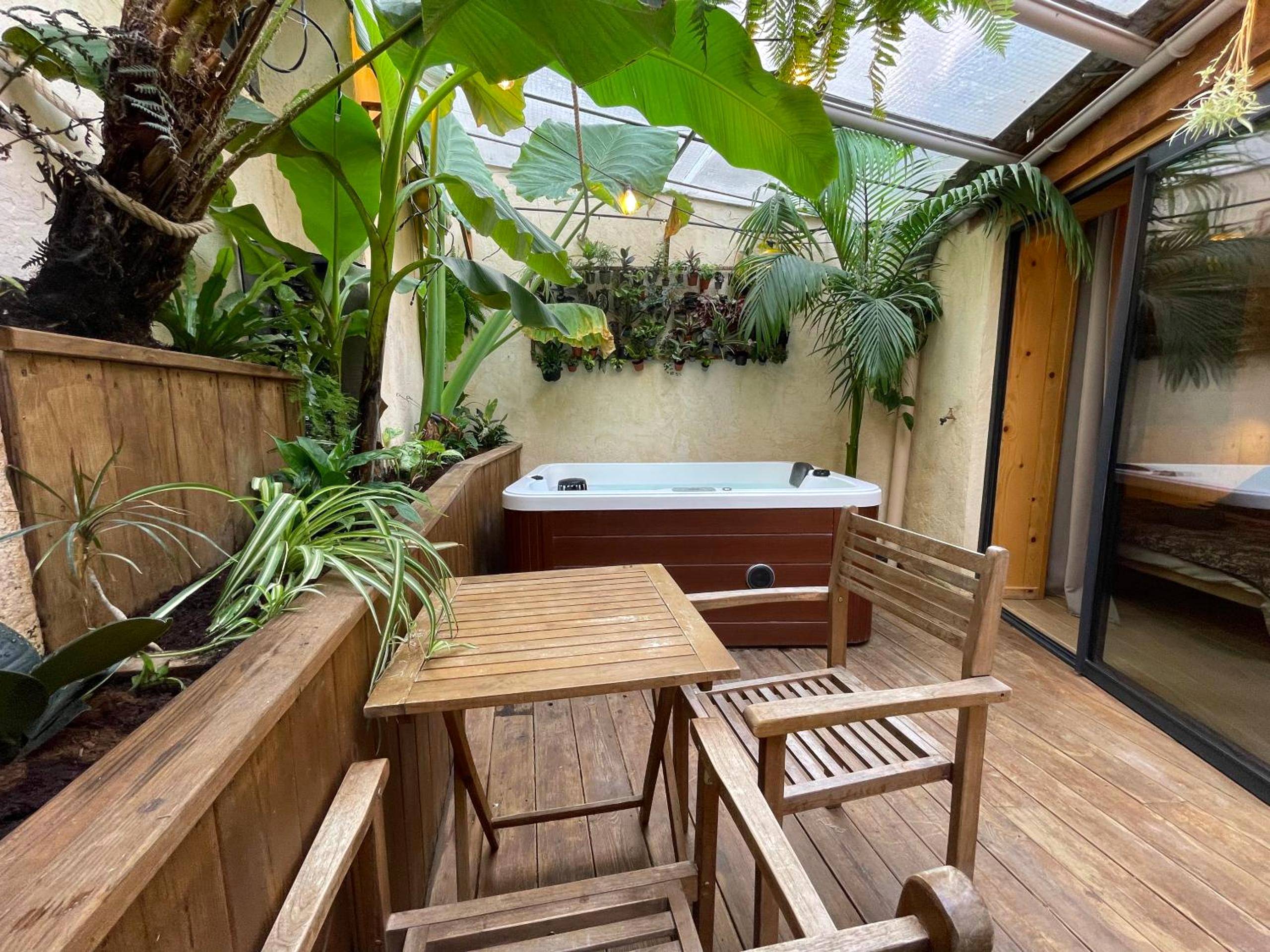 Terrasse en bois avec mobilier et jacuzzi - myinsolite - Cocon Tropical, jacuzzi, énigme