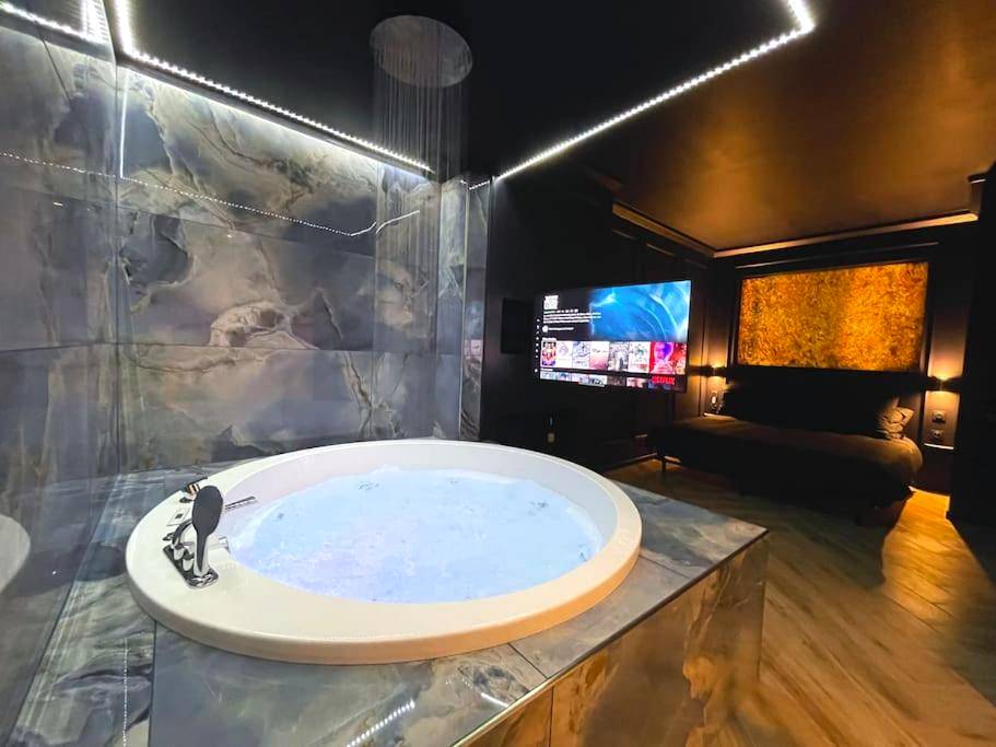Jacuzzi rond et grand écran TV - Love Room Vauvert - myinsolite - l'onyx