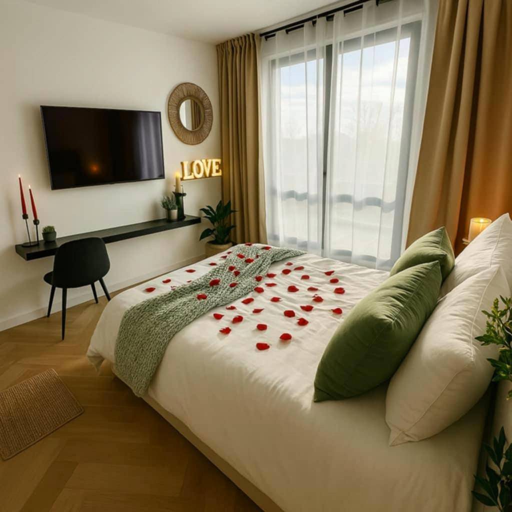 Lit double avec pétales de rose et télévision - Love Room - Le Mystic