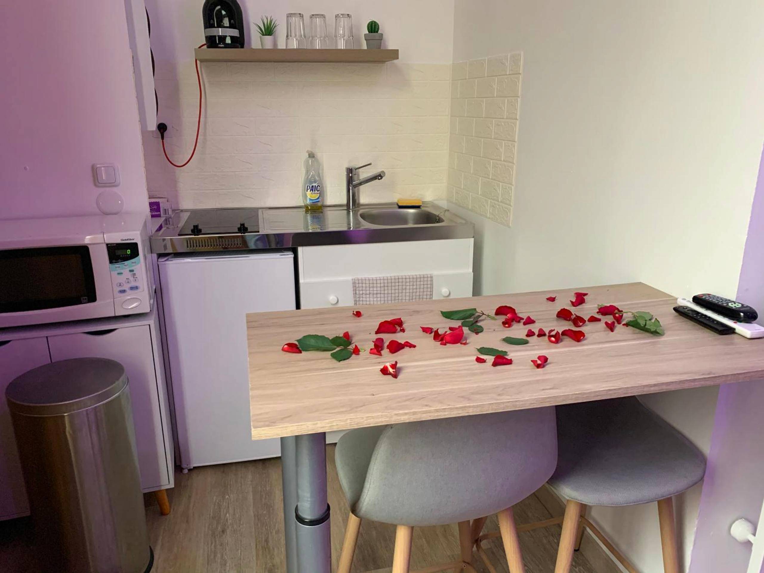 Coin cuisine et table avec pétales de rose - Appartement Spa - NAHLEO Scandinave