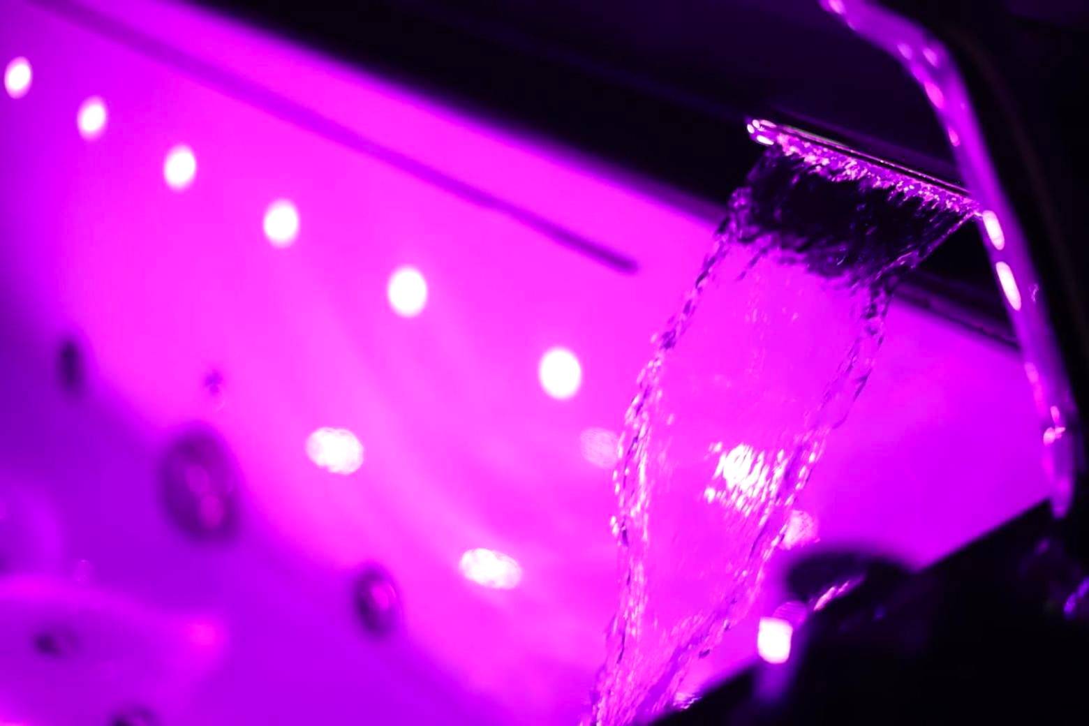 Cascade d'eau de jacuzzi avec éclairage rose - Love Room Reims - NARCISSE Balnéo, Sauna, Hammam