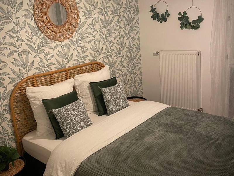 Chambre avec lit double et papier peint végétal - Nature&Spa Appartement avec Jacuzzi & Sauna privé