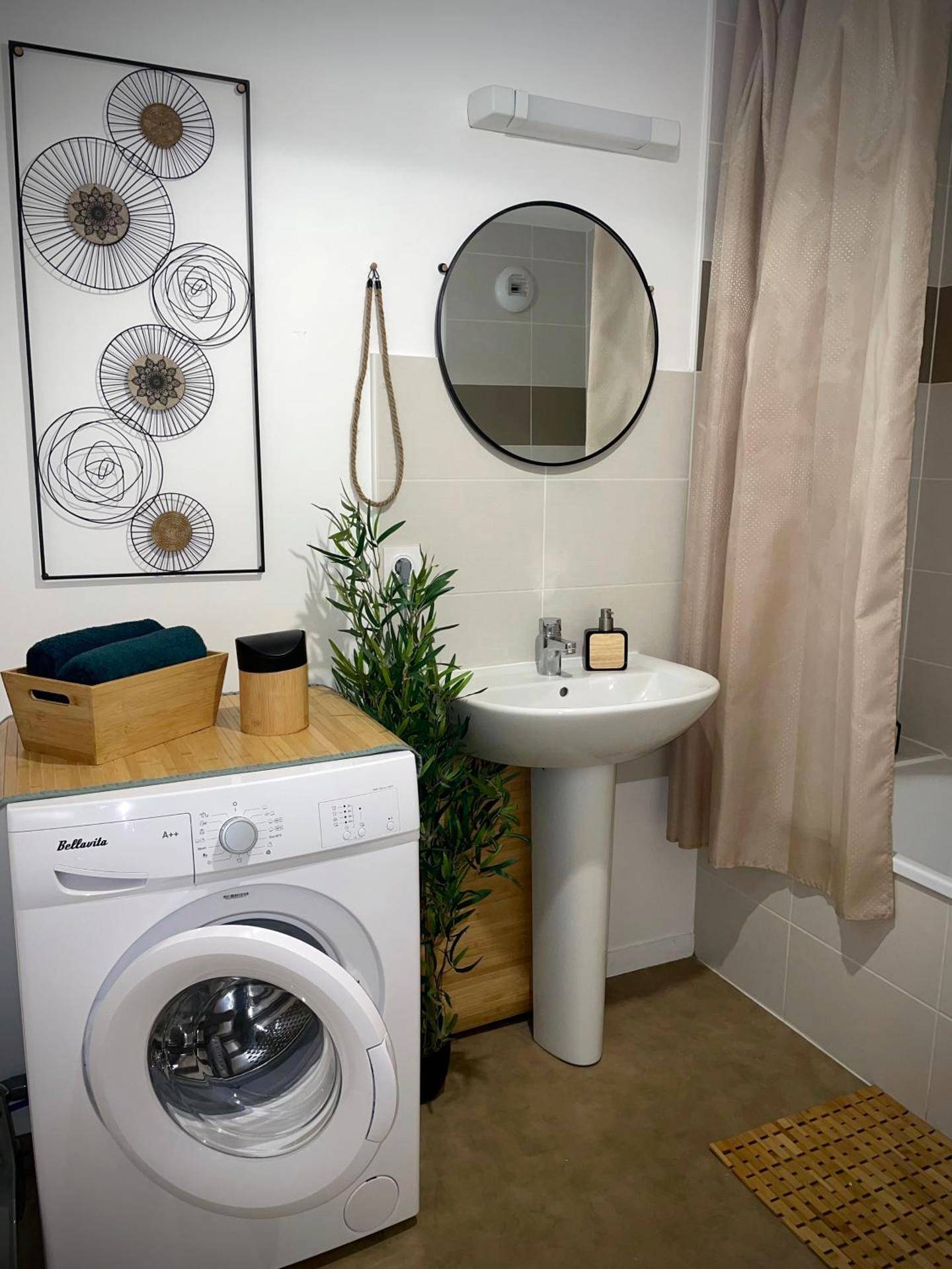 Salle de bain avec lave - linge et miroir rond - Nature&Spa Appartement avec Jacuzzi & Sauna privé