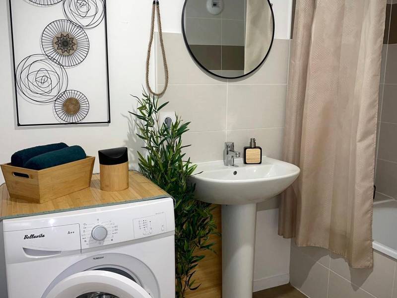 Salle de bain avec lave - linge et miroir rond - Nature&Spa Appartement avec Jacuzzi & Sauna privé