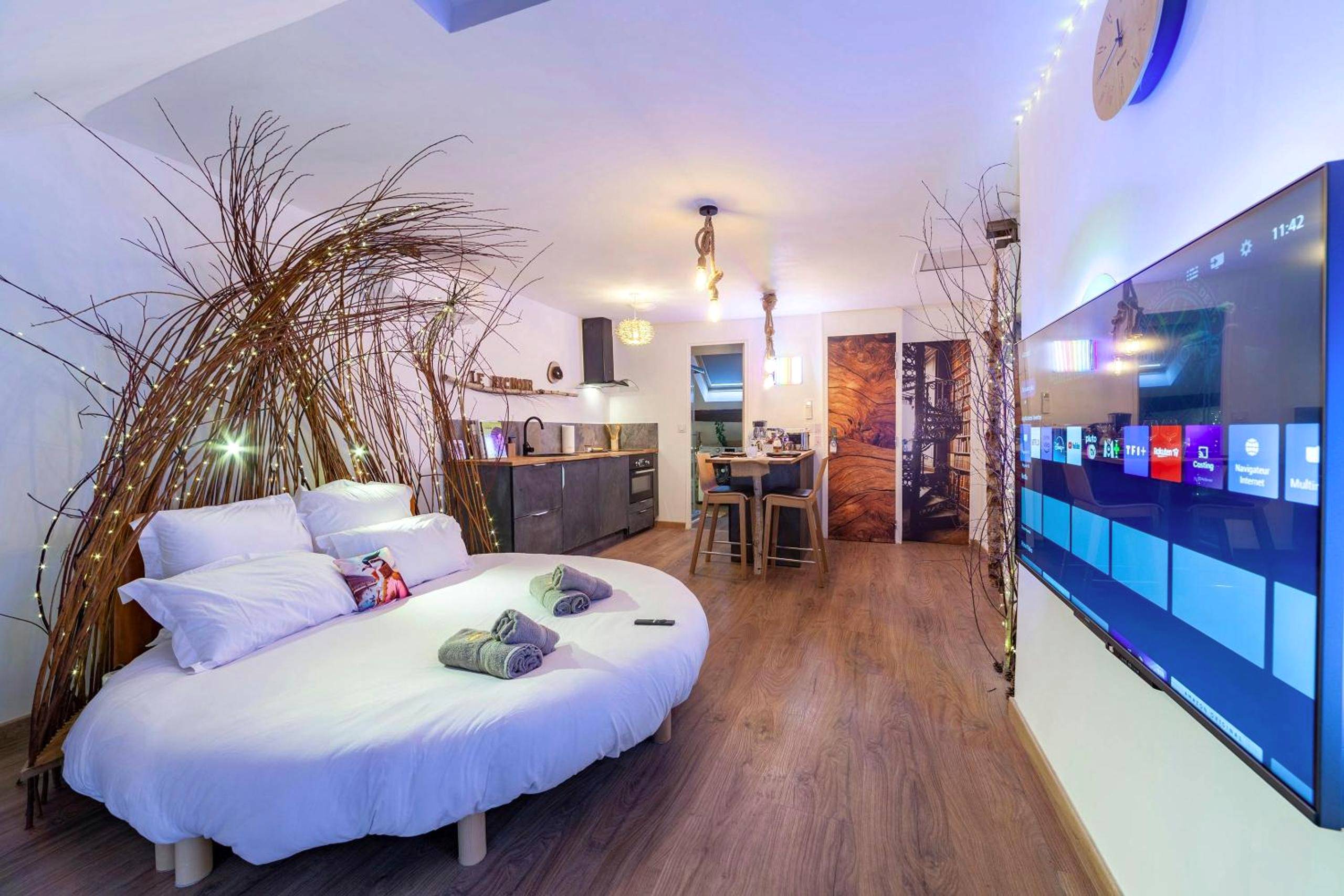 Vue d'ensemble du studio avec lit rond et TV - Le Nichoir Cosy : Évasion Bien - être et Massage