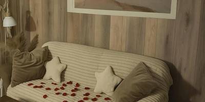 Canapé cosy avec pétales de roses et bougies - Gite au nid d'Ange