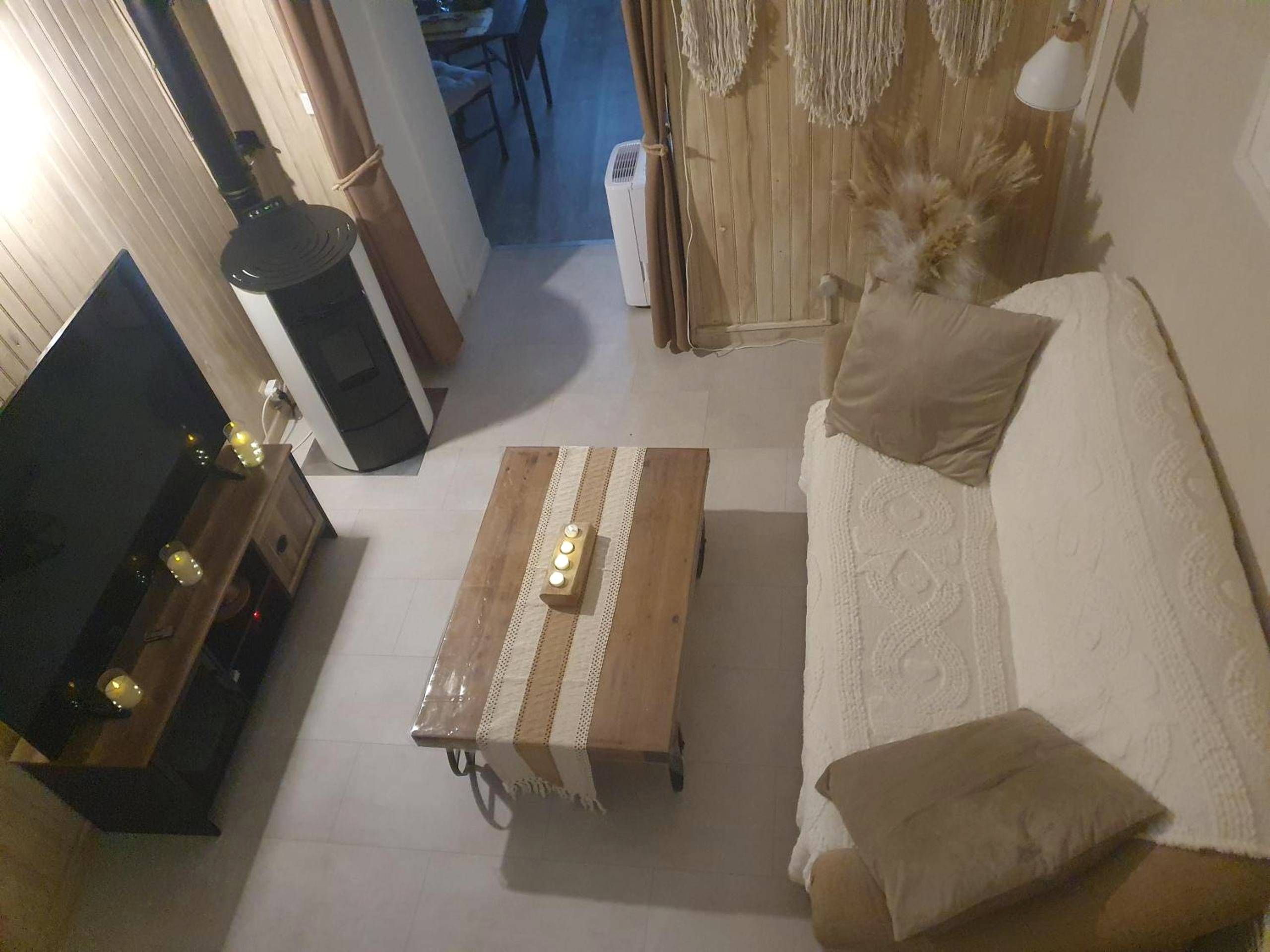 Salon chaleureux avec poêle à bois et télévision - Gite au nid d'Ange