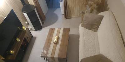 Salon chaleureux avec poêle à bois et télévision - Gite au nid d'Ange