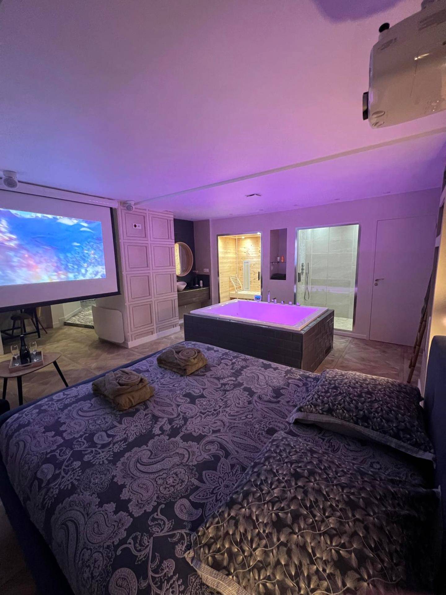 Chambre romantique avec jacuzzi rose et écran - Appartement avec Jacuzzi Sauna & Home Cinéma - Nid d'Angers