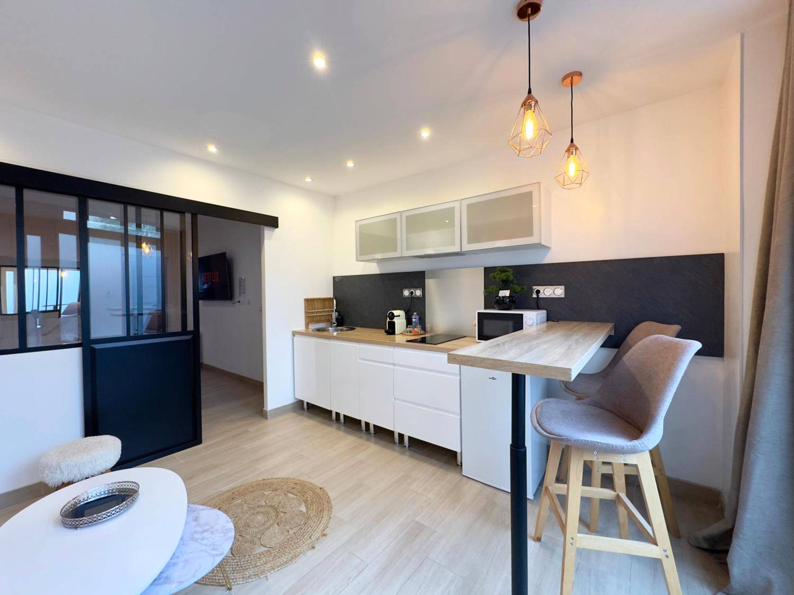 Cuisine équipée avec coin repas et tabourets - Le Nid de la Chouette by Apparts Spa Dijon