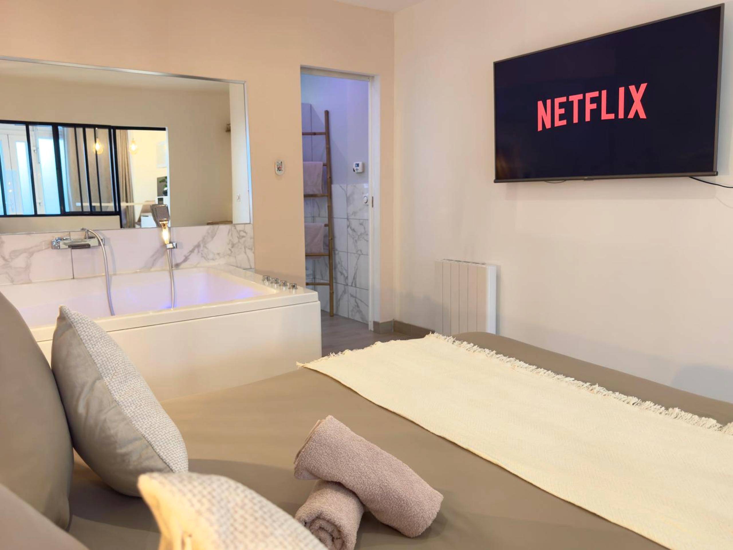 Écran plat avec Netflix face au lit et jacuzzi - Le Nid de la Chouette by Apparts Spa Dijon