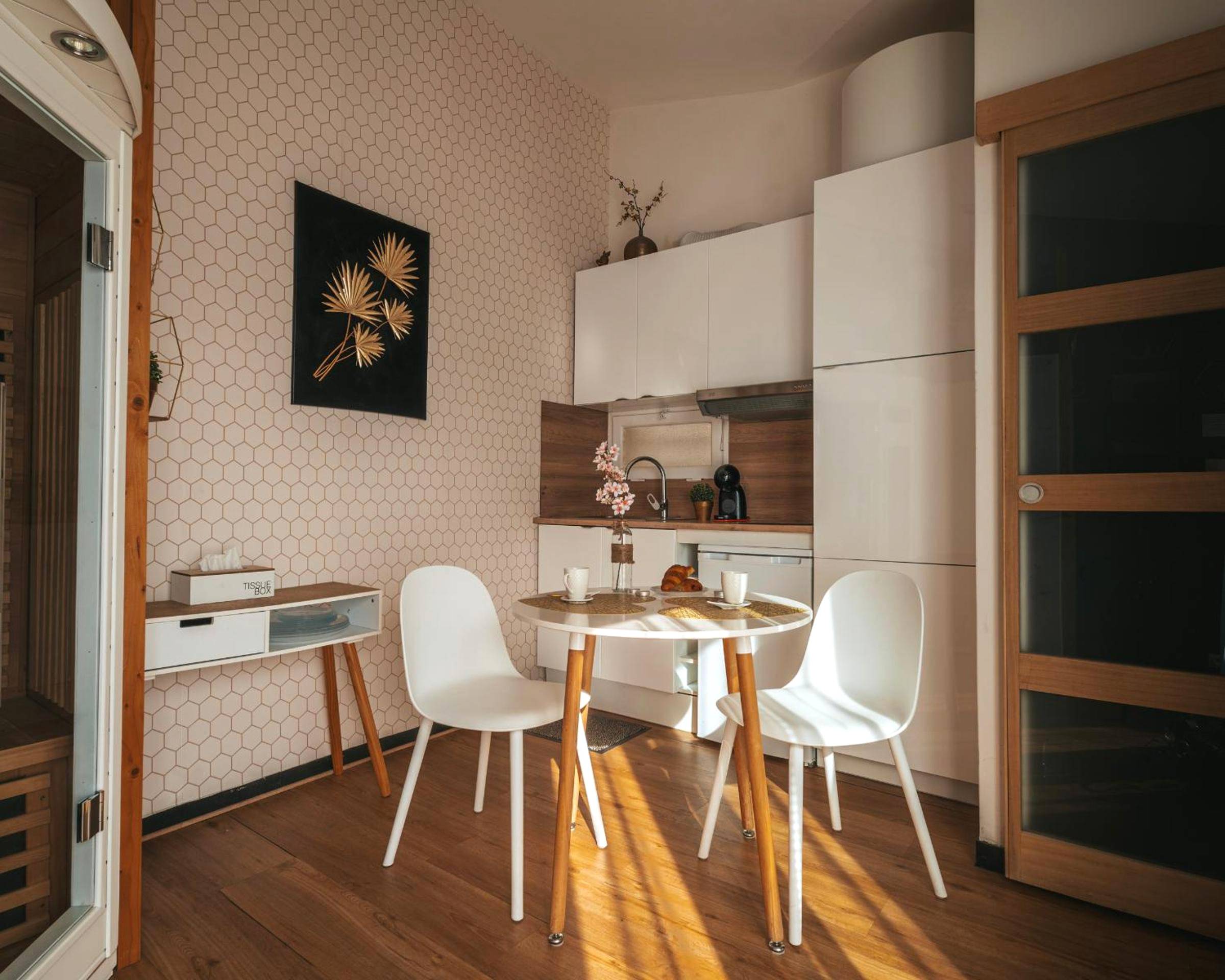 Coin repas avec table ronde et cuisine équipée - Nid Doré - Suite bien - être avec sauna & balnéo privatifs