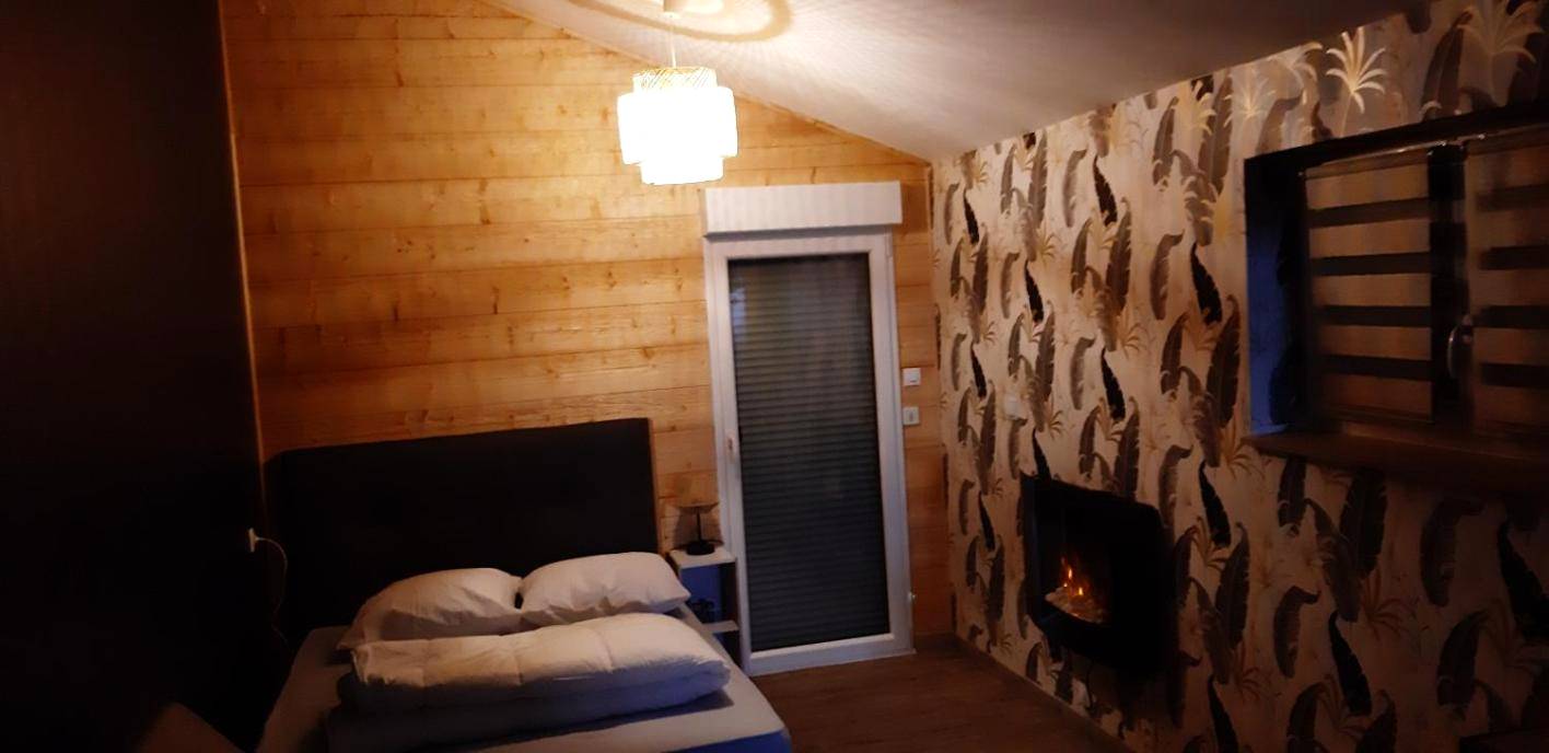 Chambre avec cheminée et mur en bois - Le nid douillet d'Alsace et sa balnéo