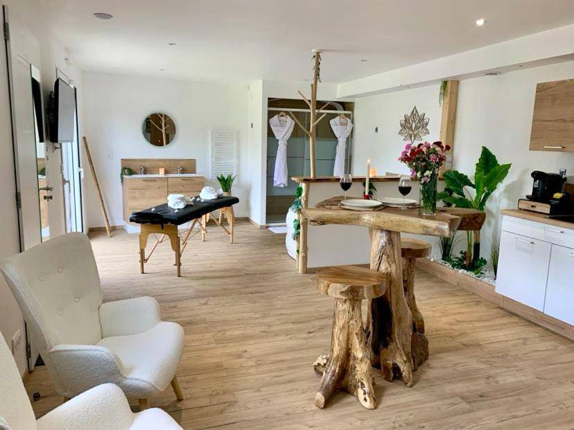 Salon avec table haute en bois brut et fauteuils - Les Nids Guérandais - Loverooms