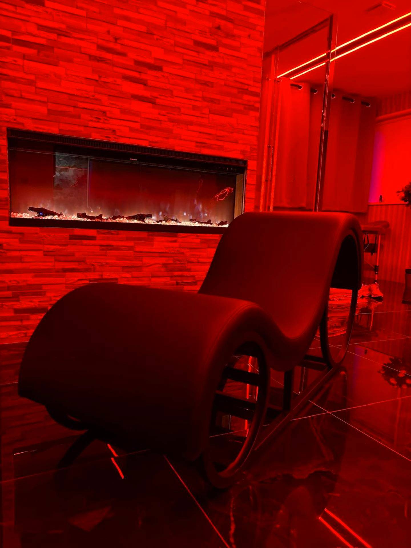 Fauteuil tantrique devant cheminée électrique - Nos Limites Room