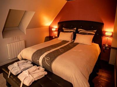 Lit double avec miroir au plafond et peignoirs - Nuances d'Alcôves