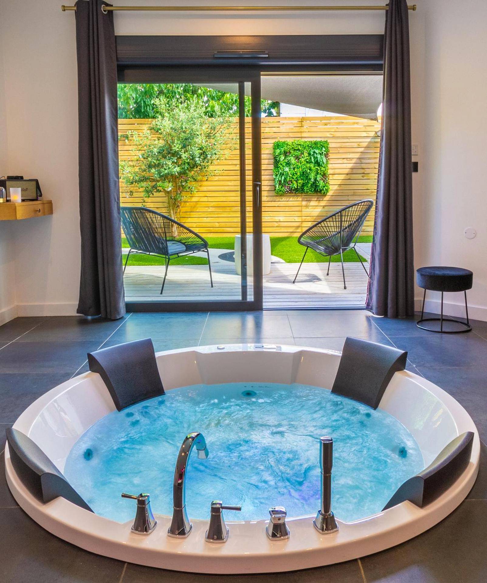 Jacuzzi rond face à une terrasse privative - Love Room Nantes - Nuit confort avec Balnéo XXL privative et Climatisation