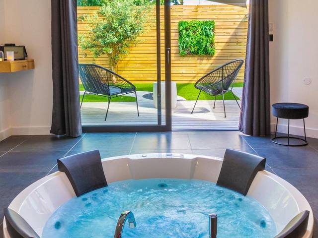 Jacuzzi rond face à une terrasse privative - Love Room Nantes - Nuit confort avec Balnéo XXL privative et Climatisation