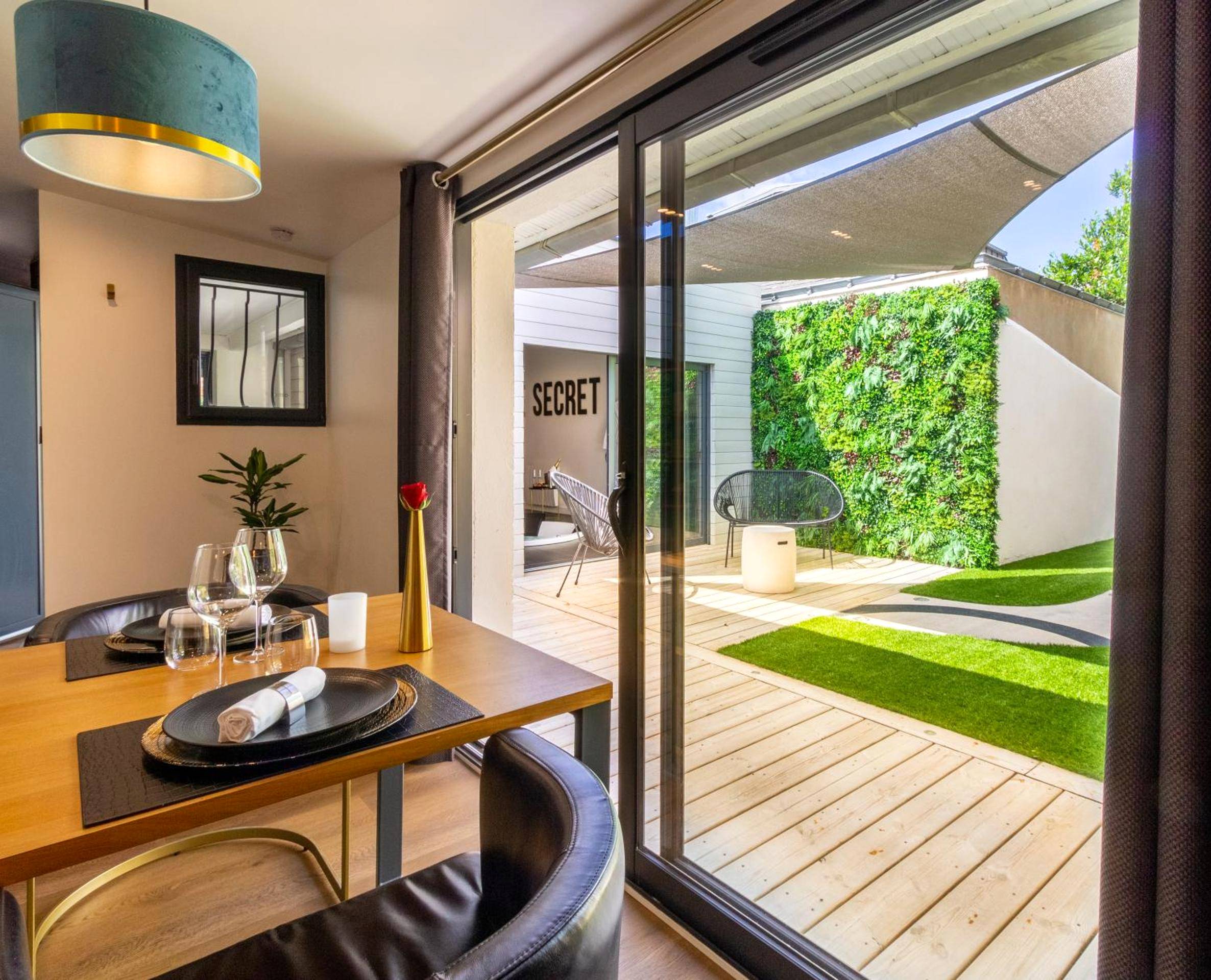 Table dressée ouvrant sur terrasse en bois - Nuit confort avec Balnéo XXL privative et Climatisation