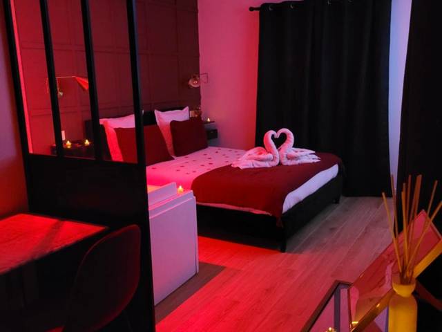 Lit double avec cygnes en serviettes et lumière rouge - Love Room Toulon - Nuit d'évasion love room avec baignoire...