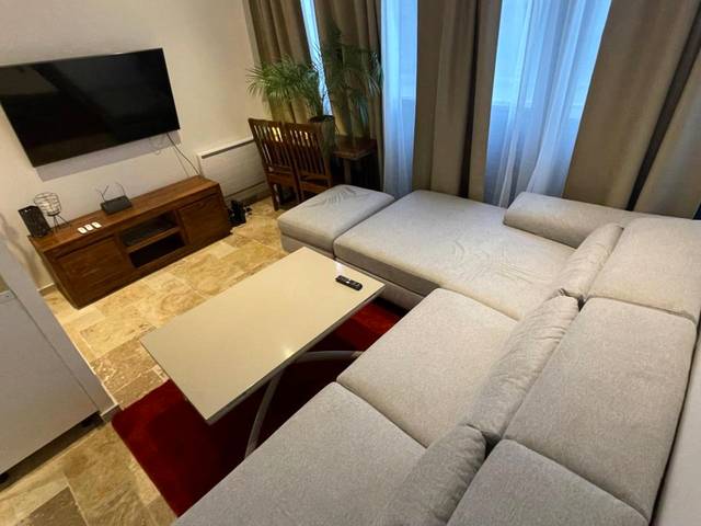 Salon avec grand canapé d'angle et télévision - By nuit - parisienne : Superbe appartement avec SPA et terrasse privée
