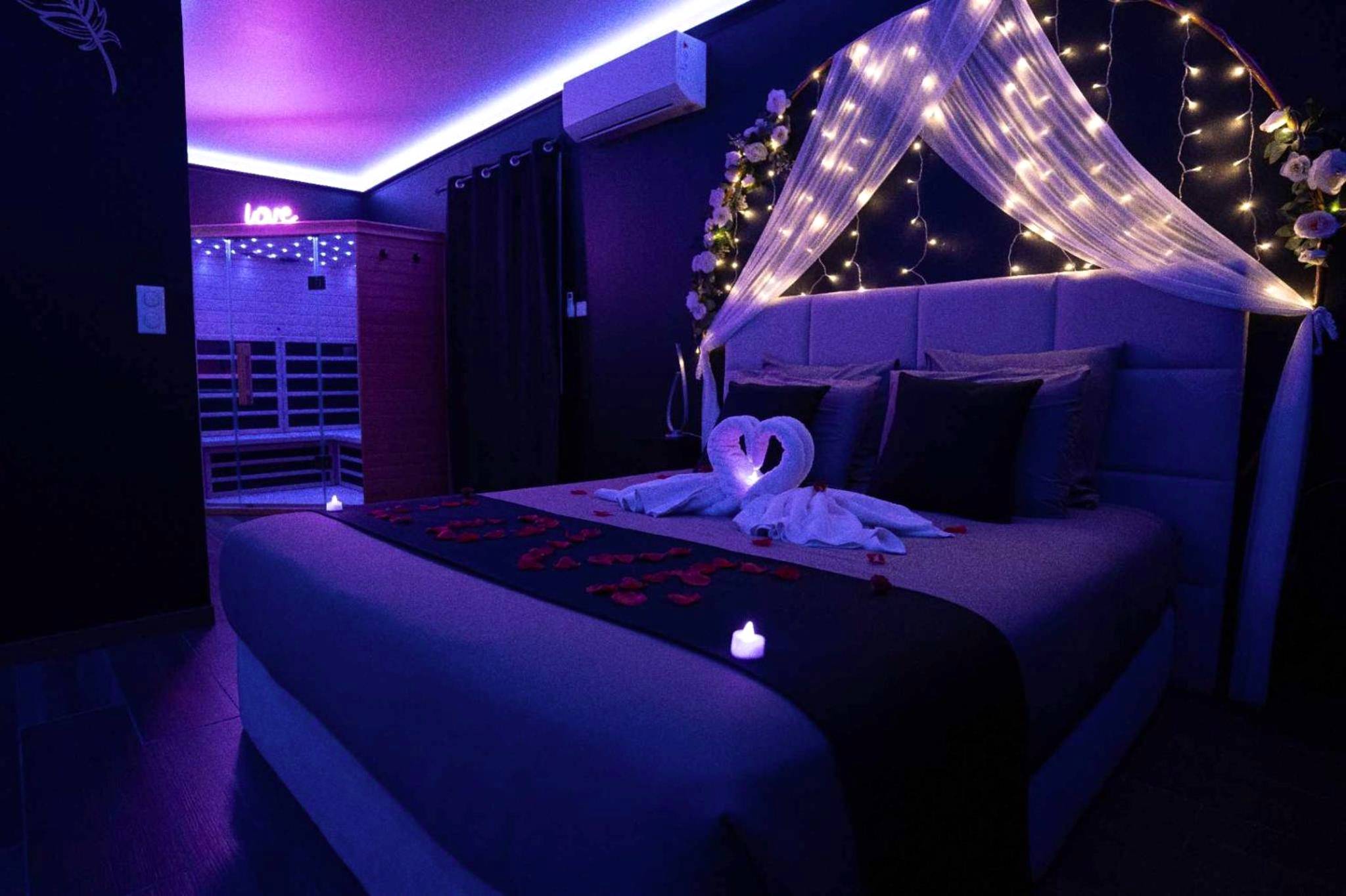 Lit double avec cygnes en serviette et pétales - LA NUIT DES SECRETS Love Room 4 étoiles avec Jacuzzi et Sauna