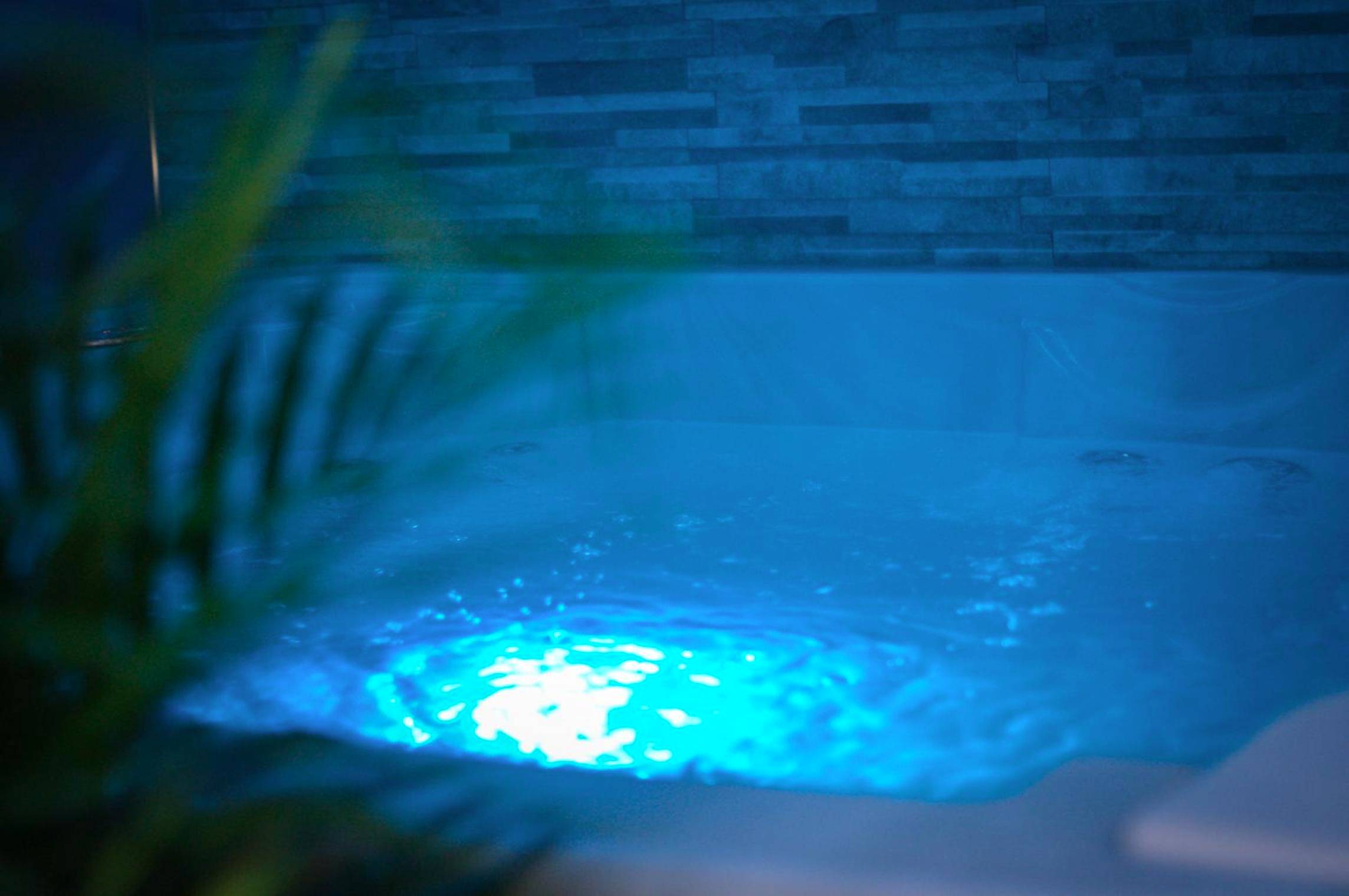 Zoom sur jacuzzi privatif avec éclairage bleu - Nuit vip spa sauna privatif
