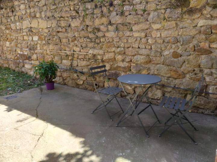 Terrasse avec table et chaises devant mur en pierre - Nuit romantique