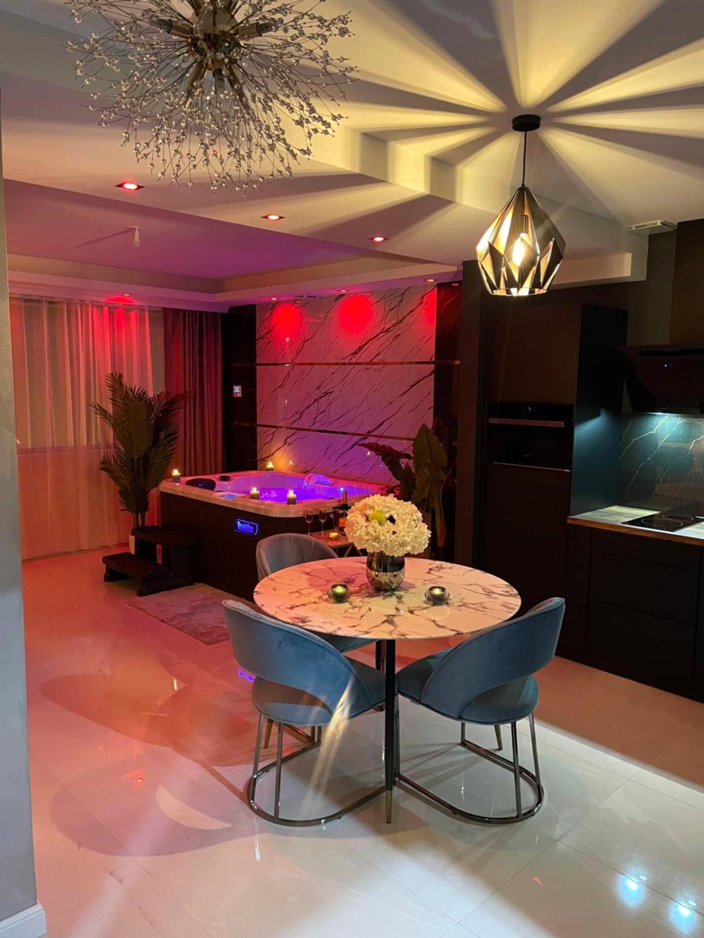 Espace dînatoire et jacuzzi avec éclairage tamisé - Love Room Chalon - sur - Saône - NUITS D'HERMES & Spa