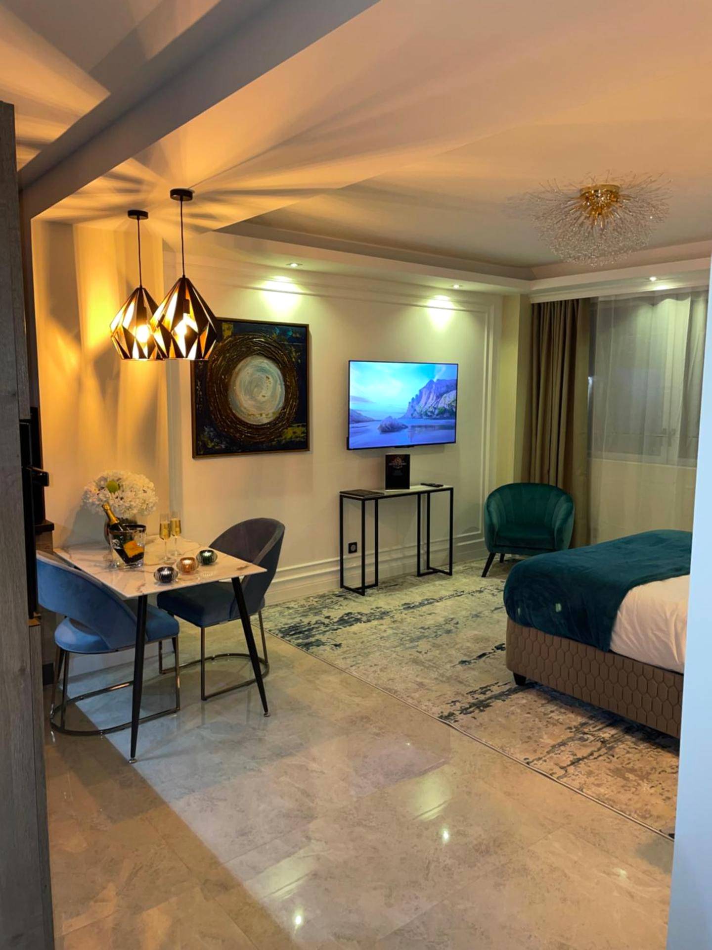 Chambre avec coin repas et télévision murale - NUITS D'HERMES & Spa