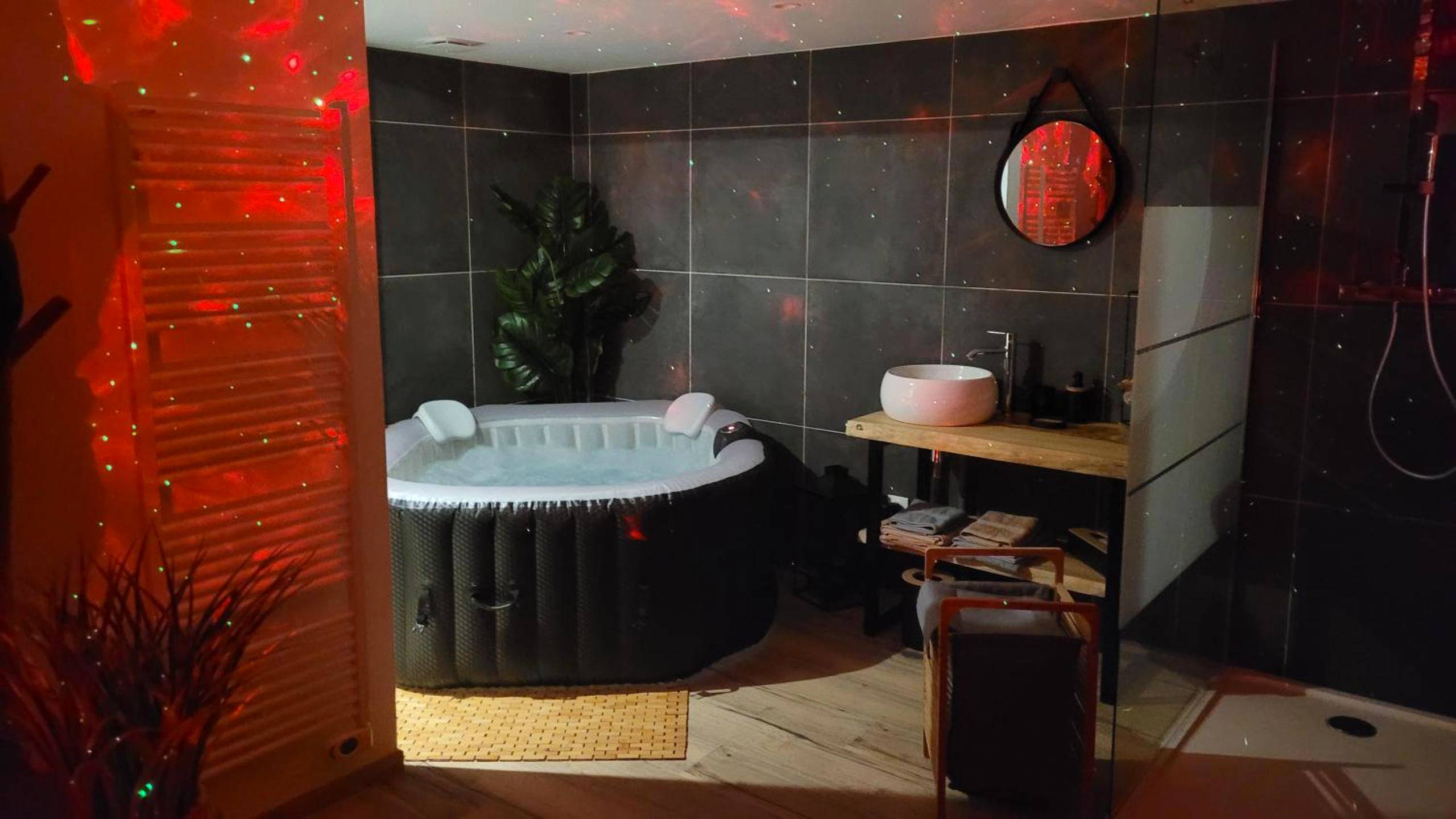 Jacuzzi privatif et vasque sous lumières d'ambiance - Ô Plaisir Ô Désir