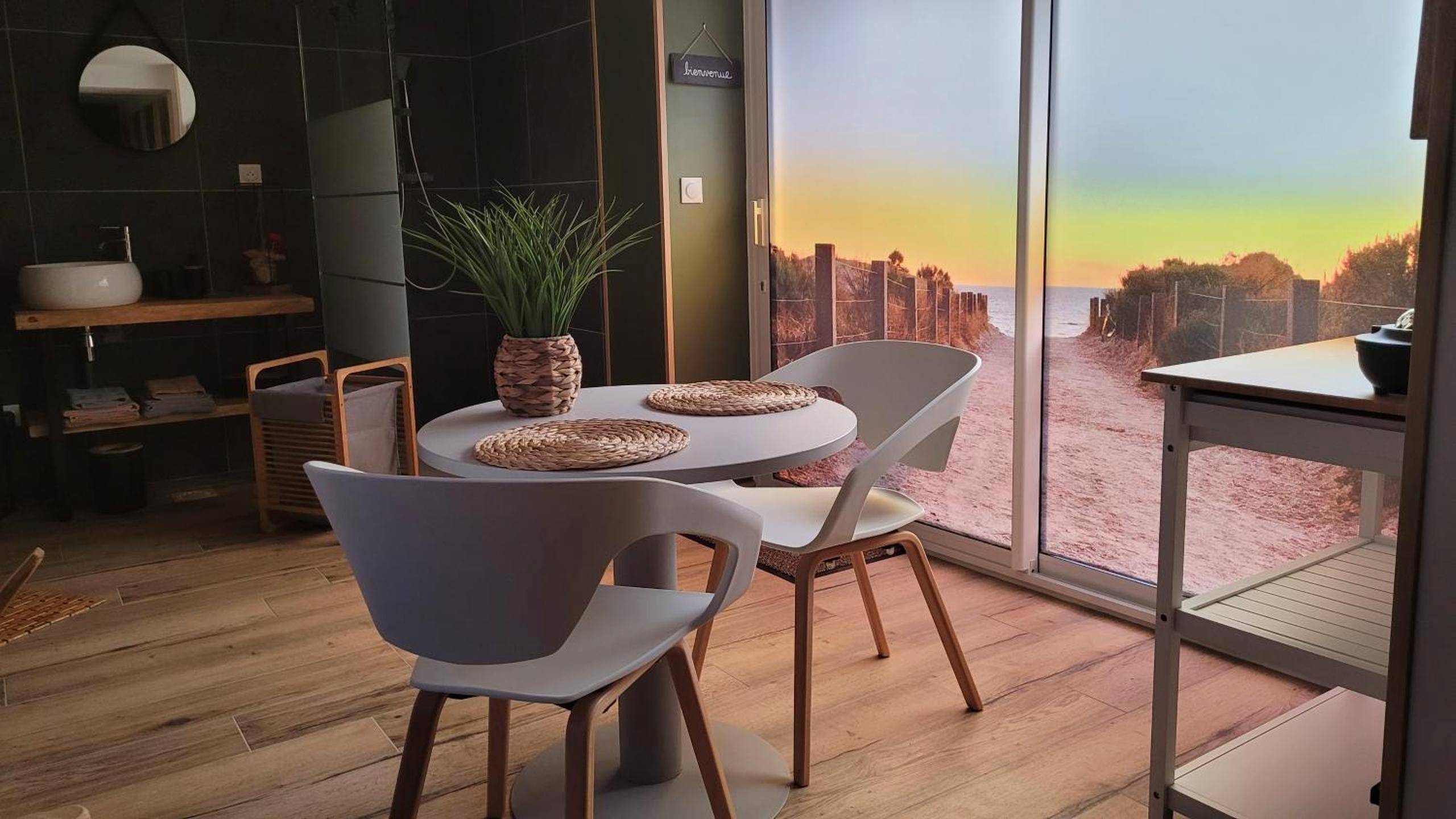 Table ronde et chaises face à la baie vitrée - Ô Plaisir Ô Désir