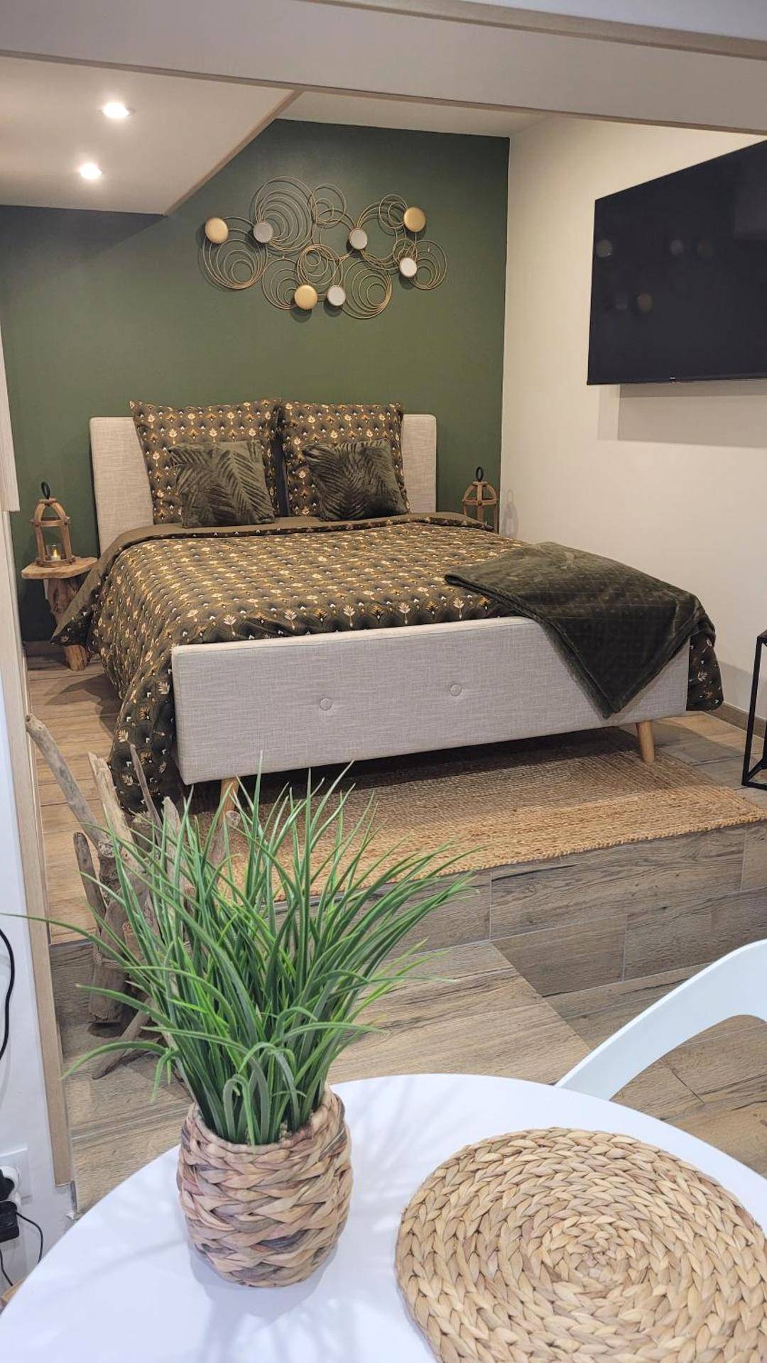 Chambre avec lit surélevé et télévision murale - Ô Plaisir Ô Désir