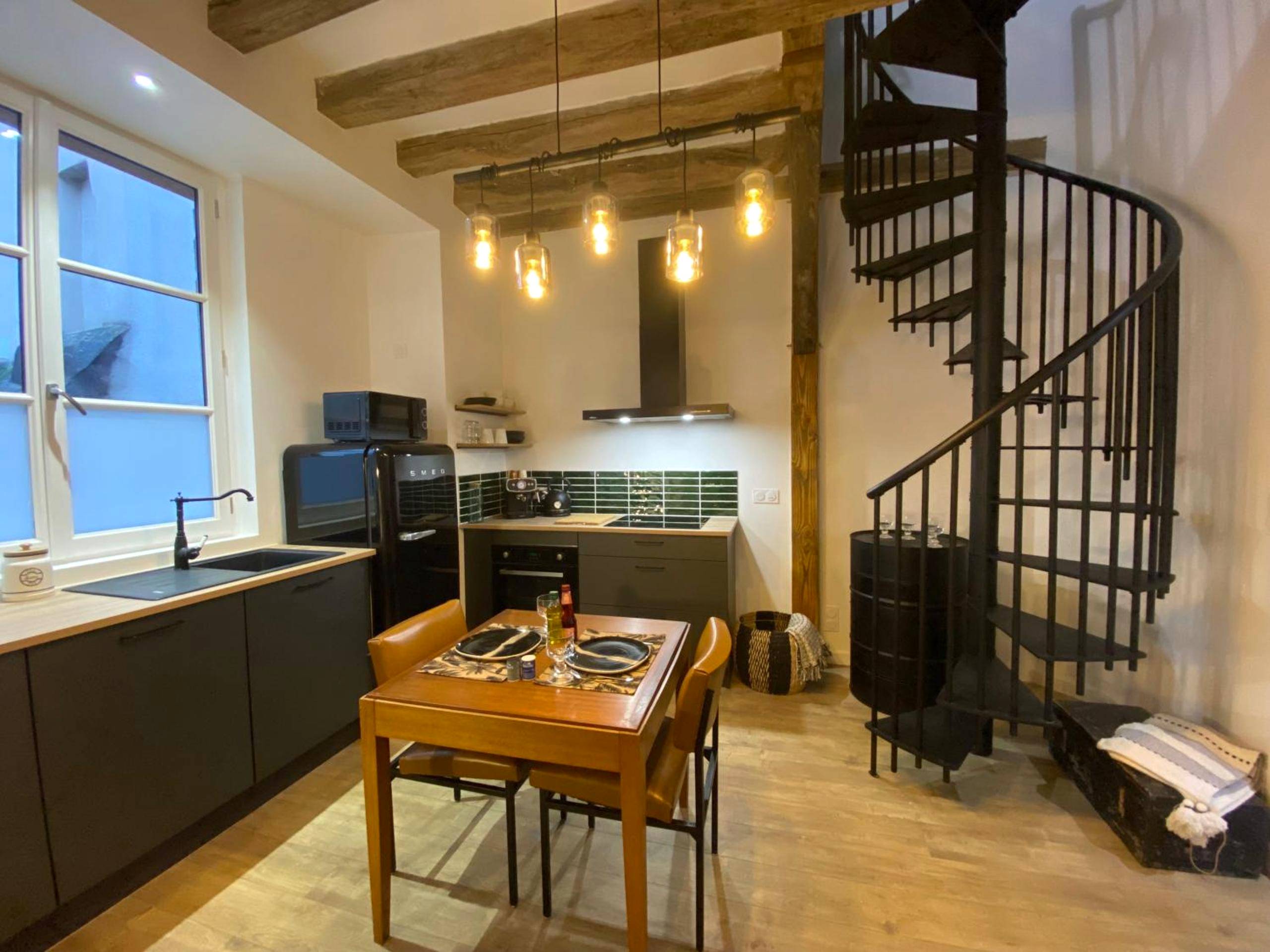 Cuisine équipée et escalier en colimaçon noir - L'Oasis Angevine - Balneo, Sauna, Home Cinema & Parking