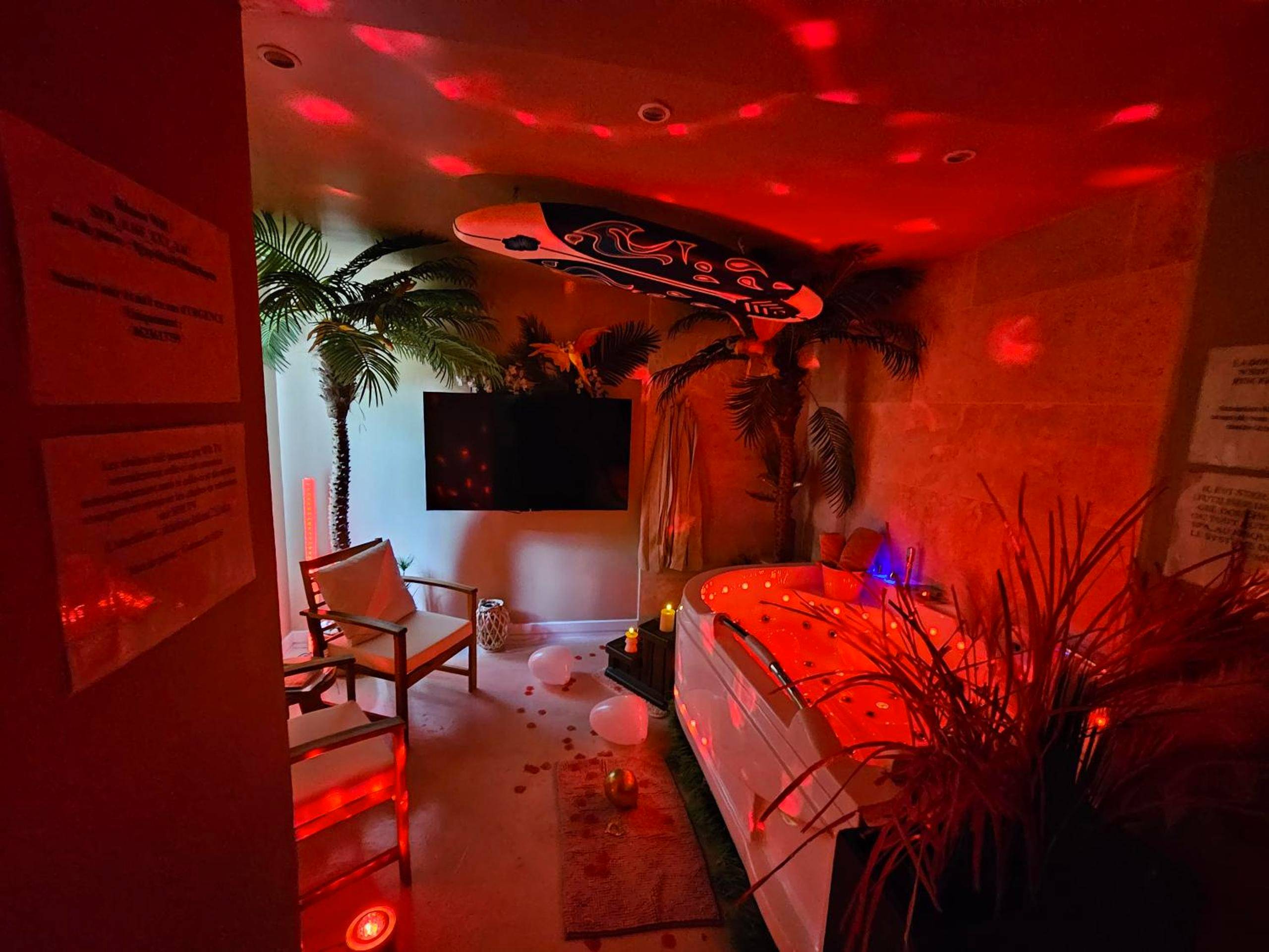 Jacuzzi privatif sous lumière rouge tamisée - Love Room La Bassée - L'Oasis Evasion de 60m2 avec SPA privatif et Design