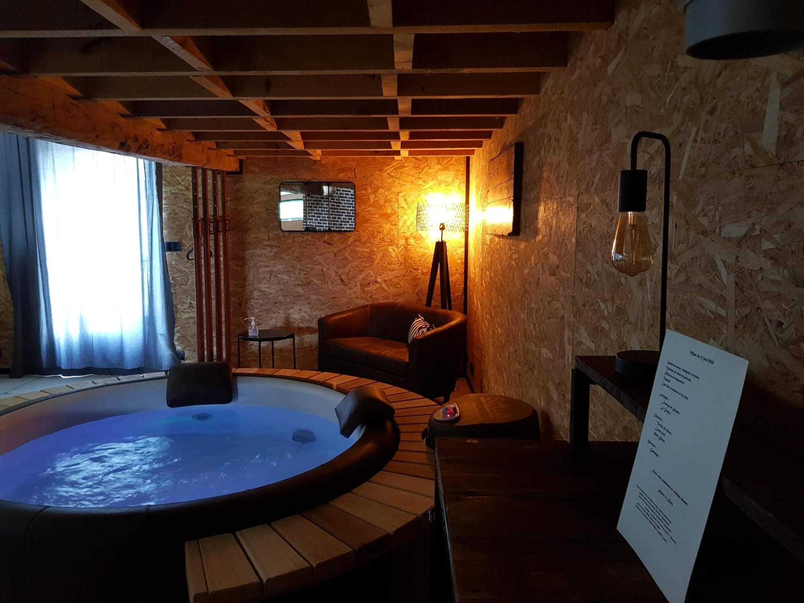 Jacuzzi privatif éclairé en bleu sous mezzanine - Love Room Zegerscappel - Odyssée - Chambre d'hôtes avec spa et sauna privés