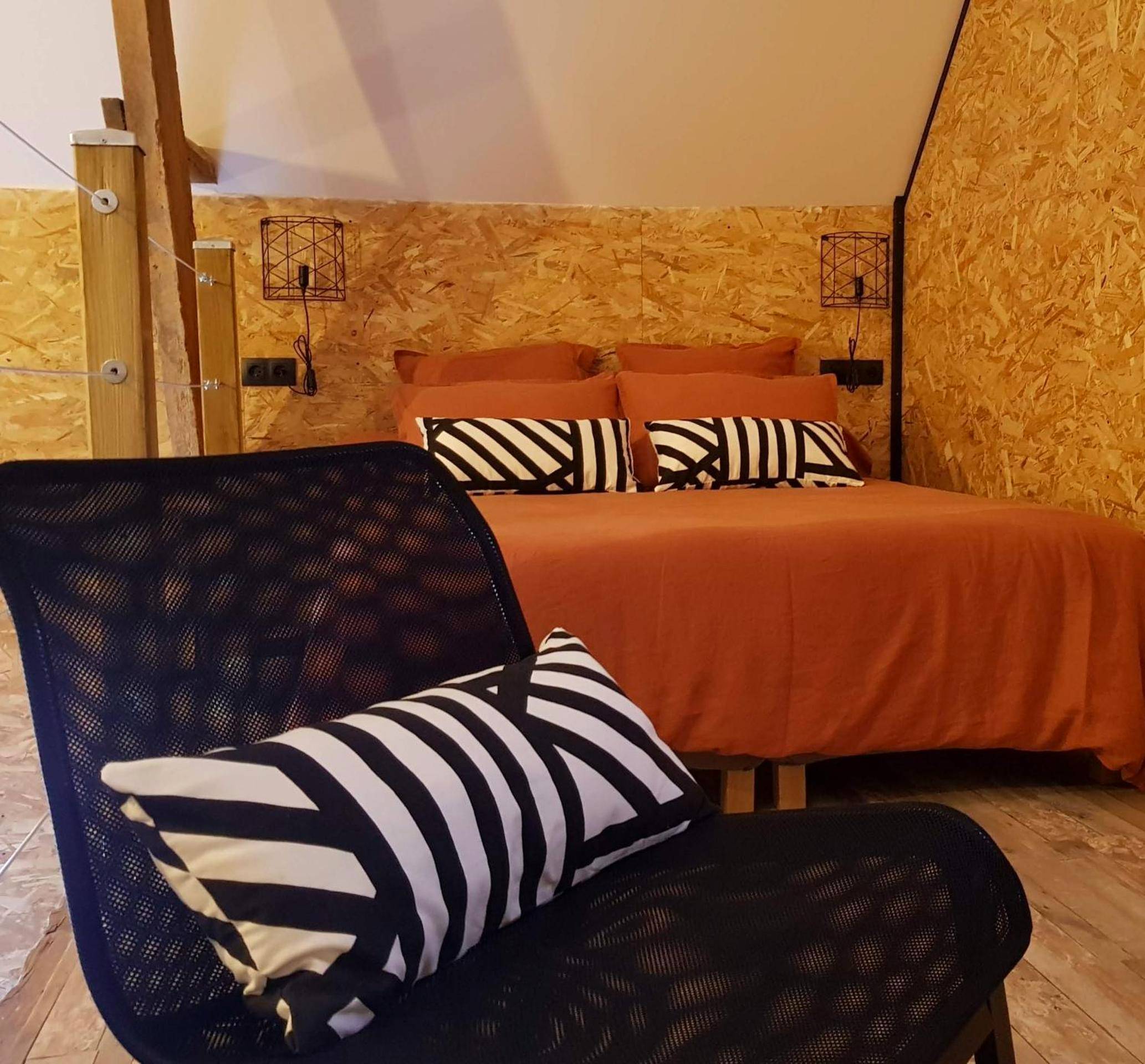 Lit double avec parure terracotta et coussins - Odyssée - Chambre d'hôtes avec spa et sauna privés