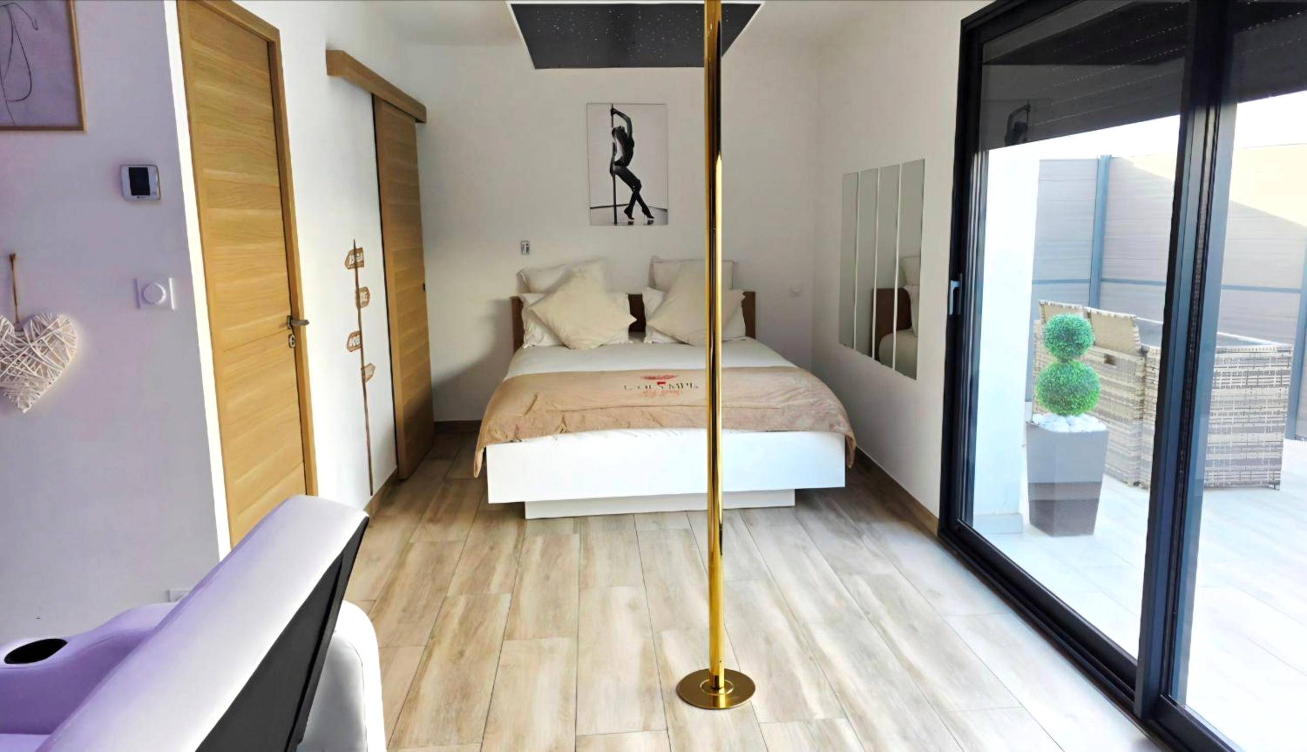 Barre de pole dance devant lit king size - Love Room Portiragnes - L'OLYMPE DES SENS