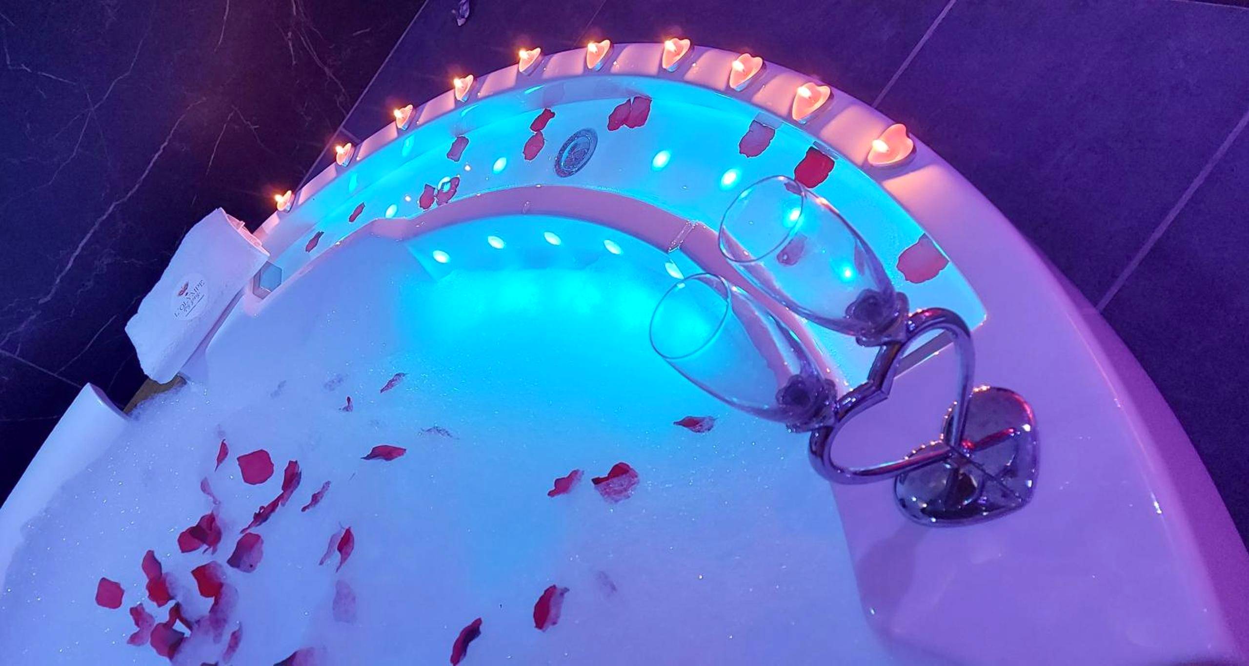 Jacuzzi avec pétales de rose et flûtes - L'OLYMPE DES SENS