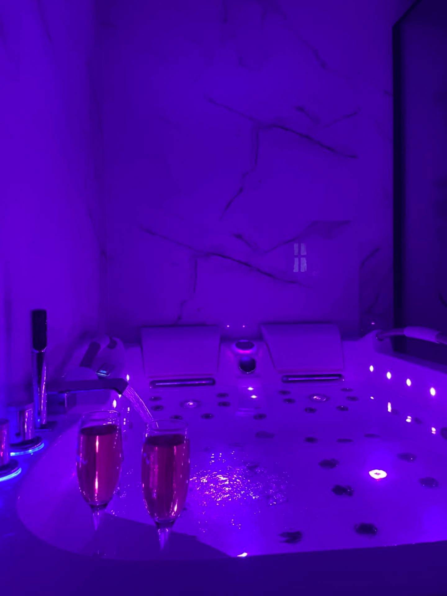 Baignoire balnéo avec éclairage violet et flûtes - Ombre et Douceur