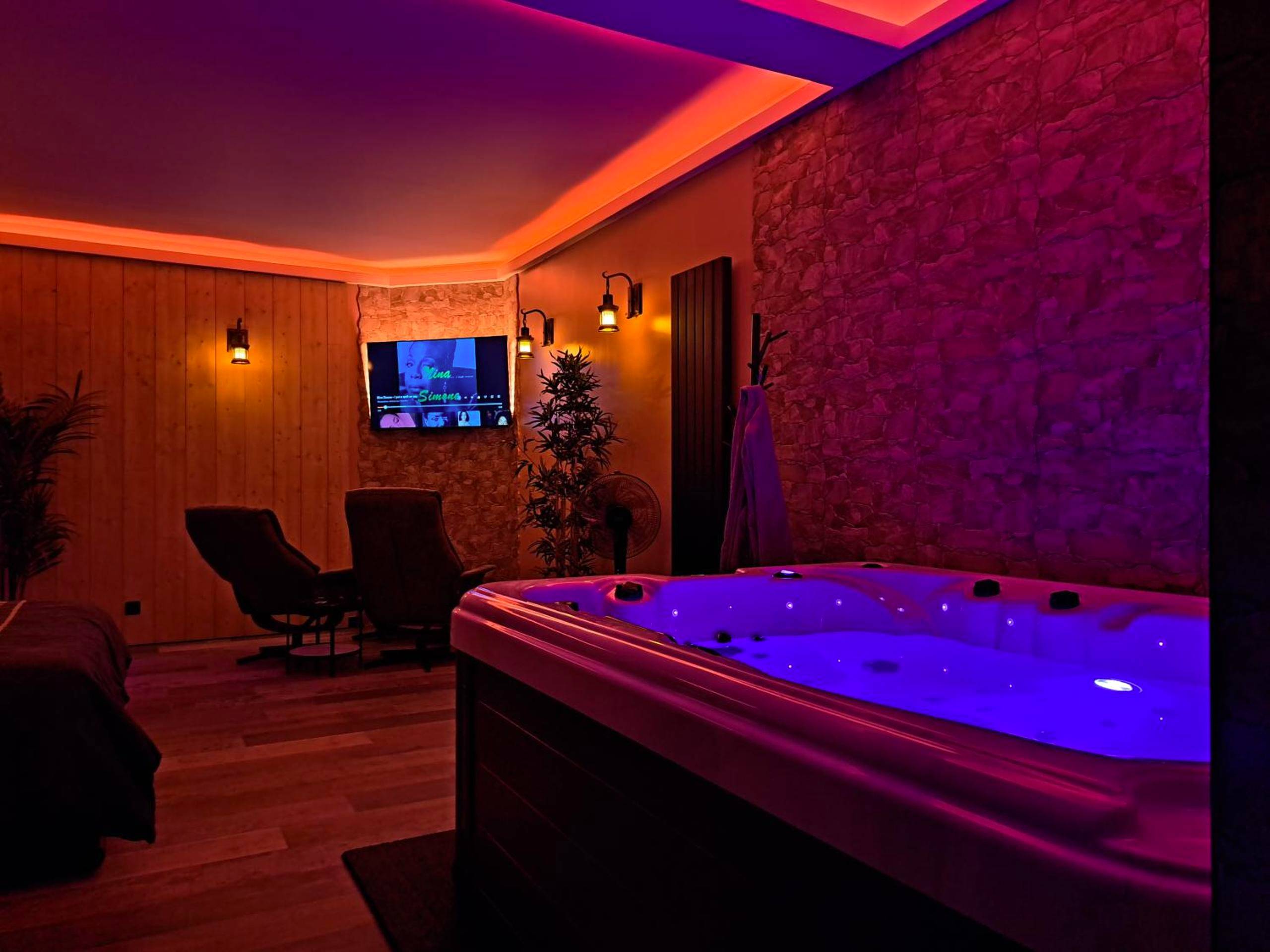 Jacuzzi privatif avec éclairage LED violet - Love Room Arras - Ospaloft, meublé haut de gamme avec spa privatif