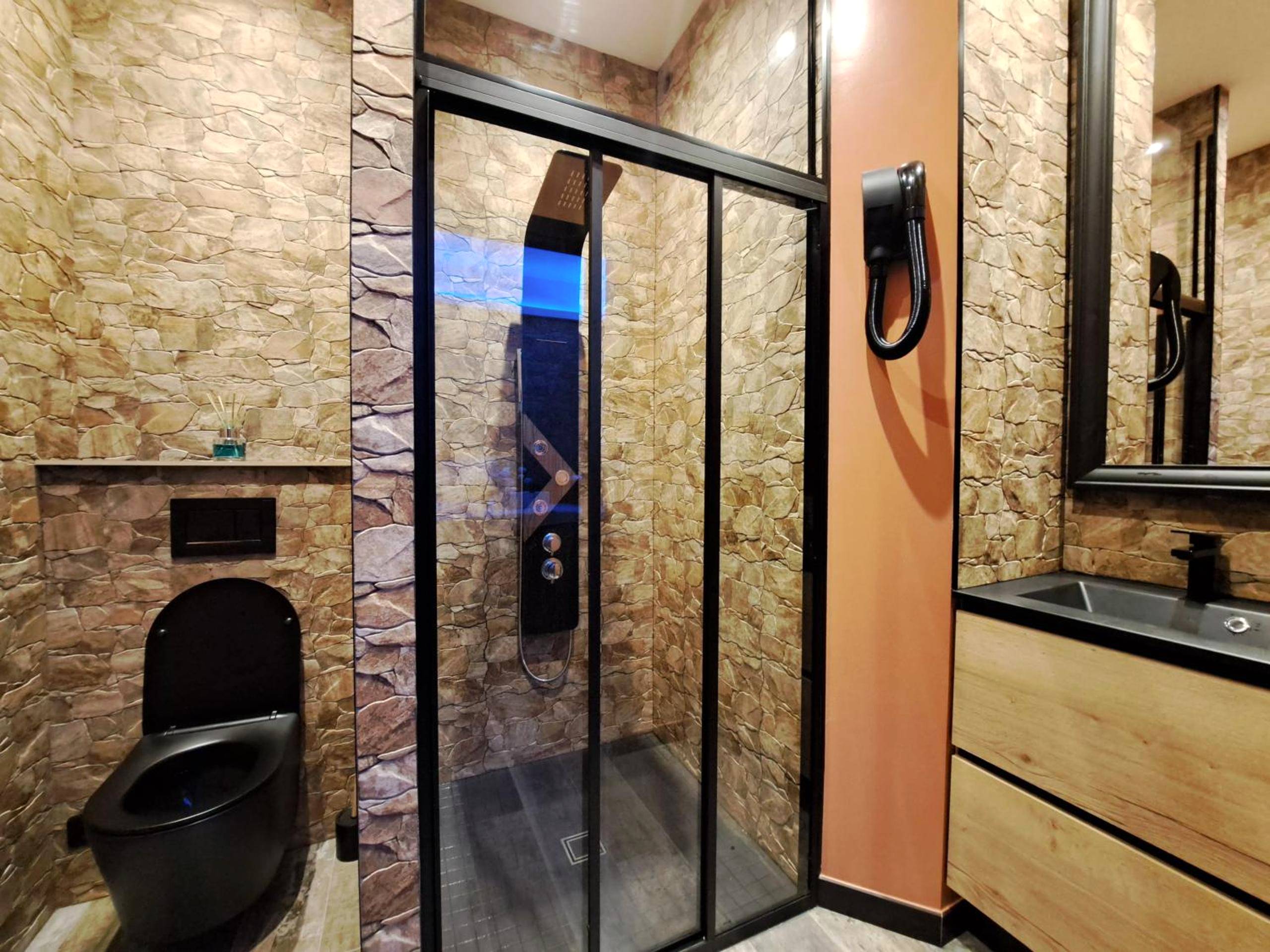 Salle d'eau avec douche à l'italienne et WC noir - Ospaloft, meublé haut de gamme avec spa privatif